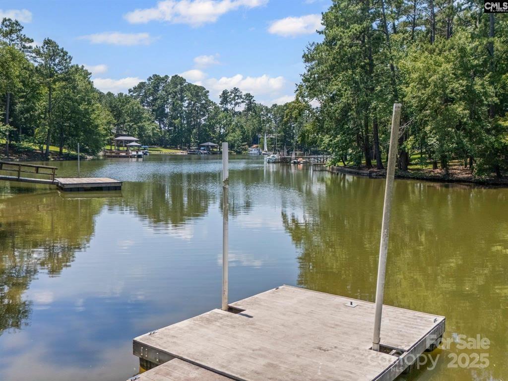 Lake Wateree Living! A home with more than meets the eye! Maybe it's the SEPARATE 910 SF Finished Room Over Garage (built in 2022), complete with a full kitchen, bath and laundry that will entertain a studio, a rental or private retreat. Maybe it's the open floor plan with lake views or the cozy cove with easy access to big water.  And a private dock and boat ramp. And then there's the covered carport under the house, with room to store all your lake toys. There is a workshop waiting for your next big idea or project or just enjoy the patio area with family & friends grilling on game day. This home isn't just a place to live, it's a place to thrive! Ready to experience lake life?