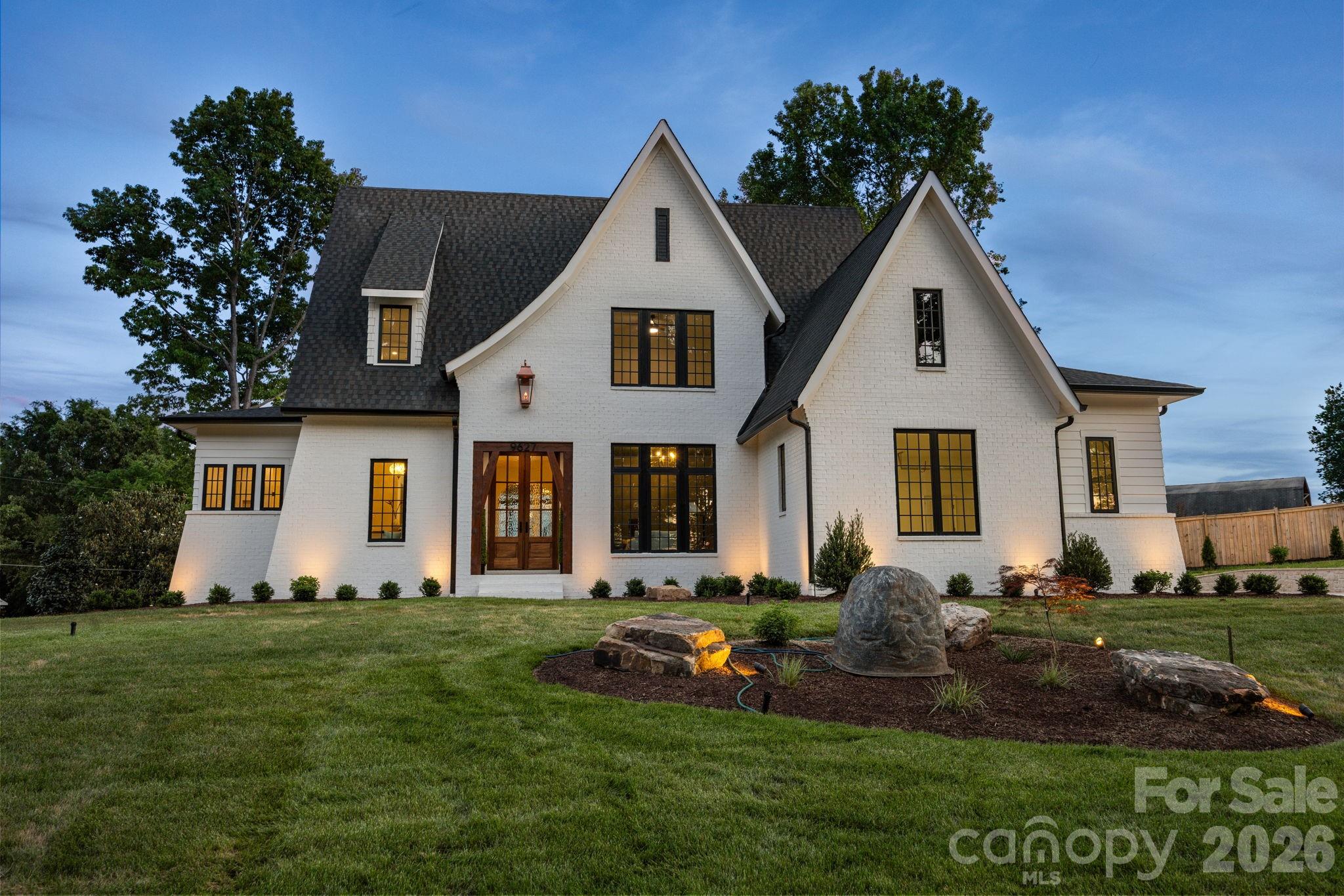 Welcome to 9627 Rivera Drive—where timeless design meets tranquil lake living, complete with lake access to Lake Norman.

This custom, one-of-a-kind home was thoughtfully crafted with a focus on timeless architecture and refined elegance. From the moment you arrive, the architectural presence stands apart—defined by steep, sloped rooflines, refined proportions, and a dramatic copper gas lantern framing the entry. A 9-foot front door welcomes you into expansive interior spaces with soaring ceilings and clean, intentional lines that reflect a level of design rarely found in today’s market. As evening falls, the home transforms with professional uplighting that highlights its architectural features—creating a truly striking presence that is truly unforgettable after sunset.

This 4-bedroom, 3.5-bath residence features high-end finishes throughout, including matte Taj Mahal quartzite countertops, custom white oak cabinetry, full spray foam insulation, and a handcrafted custom railing that adds a distinctive architectural element. The open-concept living spaces are filled with natural light, highlighted by expansive windows that frame peaceful views of Lake Norman from nearly three-quarters of the lot. The living room’s statement fireplace and wood beam accents create a space that feels both elevated and inviting, while the kitchen is a true centerpiece—designed for both everyday living and effortless entertaining.

The primary suite is a retreat of its own, offering beautiful lake views, a spa-like bath with a full soaking tub, walk-in shower, and a seamless connection to the custom walk-in closet. Upstairs, thoughtfully designed spaces include a Jack-and-Jill bathroom layout along with a versatile bonus room—perfect for a media room, playroom, home gym, or additional office space. Additional features such as a dedicated library with custom white oak built-ins and a functional mudroom add both character and practicality.

Outdoor living is equally intentional with a screened-in back porch complete with propane lines run for heaters to keep you cozy, perfect for year-round enjoyment. Car enthusiasts will appreciate the nearly 12-foot garage ceilings designed to accommodate a lift, along with a 60amp EV charger plug.

Tucked on a quiet, low-traffic road, this home offers a rare sense of privacy and calm. Enjoy the benefits of lake life without the constraints—this neighborhood provides lake access, allowing you to keep your boat at home and easily launch just minutes away.

No detail was overlooked in the design and execution of this home—creating a space that feels as special as it is functional. If you’ve been searching for a home that stands apart from the rest—this is it.