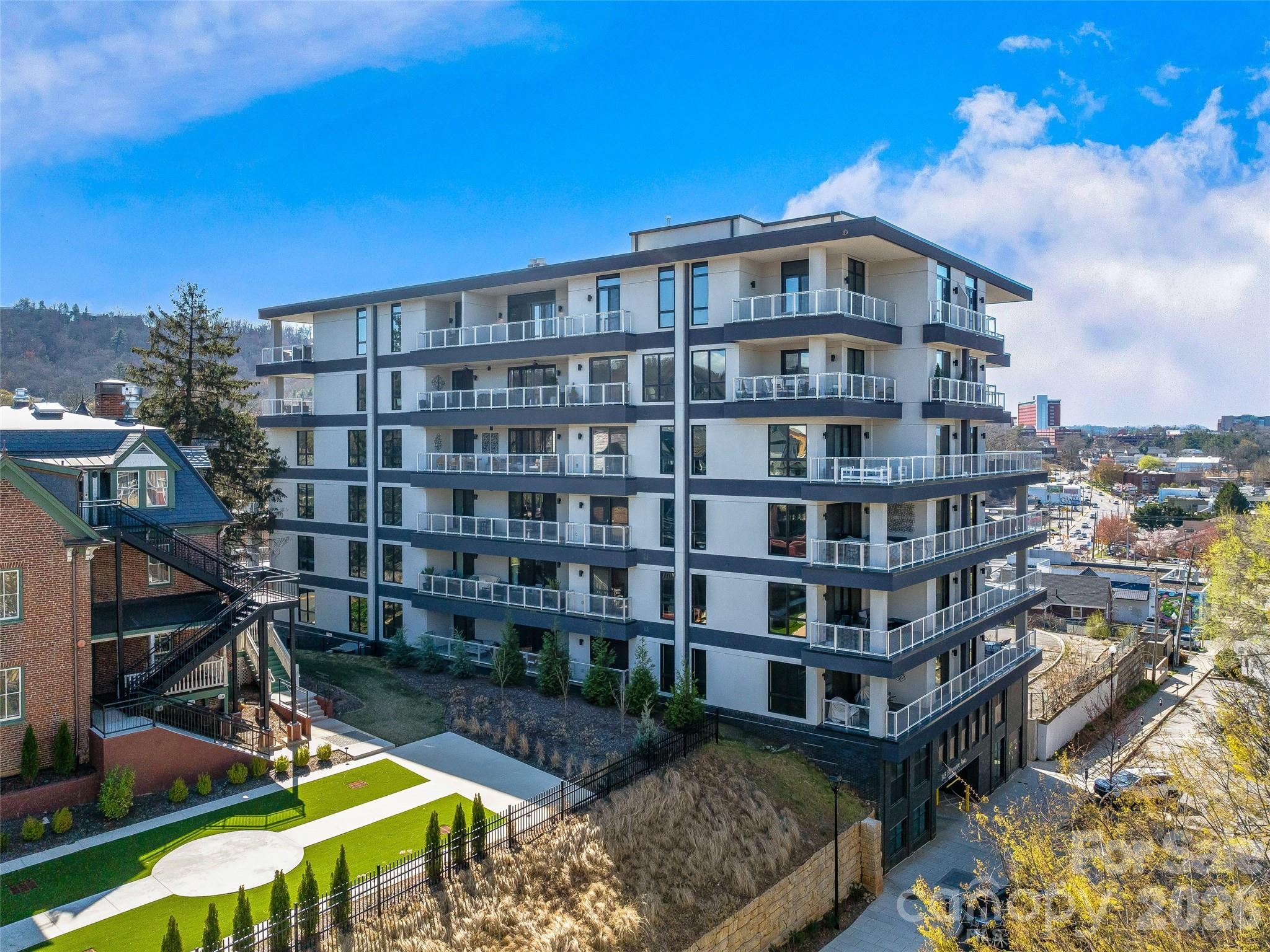 6TH FLOOR UPTOWN VIEWS & MT PISGAH! Experience modern mountain luxury in the heart of vibrant Downtown Asheville from this first-time offered, north-facing home with unobstructed views of Uptown Asheville. This two-bedroom split plan/two full bath condominium at 145 Biltmore offers stunning uptown and mountain views from the 6th floor. Enjoy a spacious wraparound balcony/deck plus two Juliette balconies, perfect for soaking in the scenery, including Mt. Pisgah. Imagine the Downtown twinkle of lights, mountain views, and overlooking some of Asheville's most historic homes. The well-designed open-concept layout features one-level living, a private primary suite, dining area, generous storage, and one gated garage parking space—rare in downtown. Step outside to Asheville’s finest restaurants, breweries, shops, arts, and entertainment. Luxury, location, and lifestyle await! An additional parking space is available if desired.