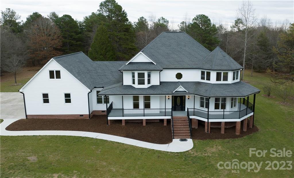 Absolutely breathtaking at first glance! Settled in on over 6.5 acres of land where there's no HOA and horses are welcome! Fancy your eyes on that wrap-around covered porch with an additional screened porch showcasing gorgeous views of the luscious greenery and trees. Make your way inside to see the magnificent recently remodeled home with over 4200 sq ft giving you lavish accommodations to entertain, relax and enjoy some tranquil privacy! Radiant natural light shines through highlighting the neutral tones and beautiful flooring. Share great times with guests with an open floor plan, bonus room, and rec room! Between the two floors, there are 4 bedrooms, 3 full baths, and 2 half baths! Take in the views from your primary suite on the upper level with an impressive private bath featuring a soaking tub, walk-in shower, and dual sink vanity with storage. Add in the 3-car garage and Clover Schools - it's truly the perfect home you've been dreaming of and its ready for you to move right in!