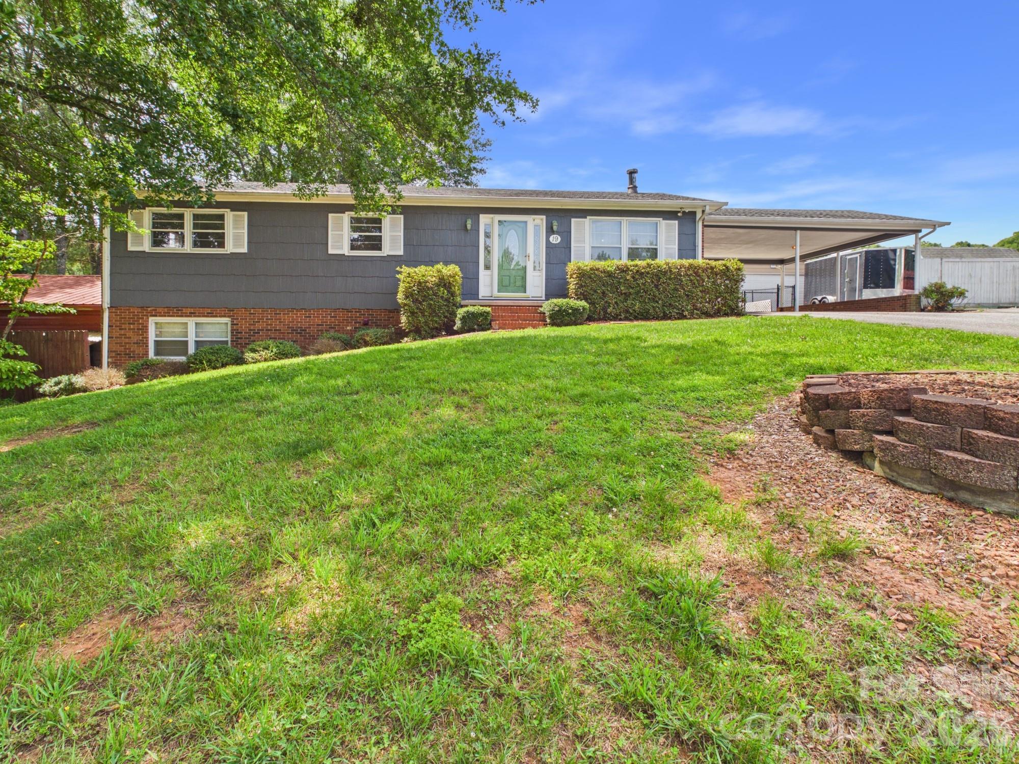 Located in the highly sought-after Bethlehem community, this versatile property offers an exceptional combination of comfortable living space, workshops, garages, and hobby areas. The main level features 1,325 square feet with 2 bedrooms, 2 full baths, a spacious sunroom, and an open floor plan that creates an inviting flow for everyday living and entertaining. Step outside to a welcoming patio that's perfect for grilling, relaxing, or hosting friends and family. Car enthusiasts, hobbyists, woodworkers, and DIYers will appreciate the abundance of functional space this property provides. Outside you'll find a 24x20 metal storage garage, a 24x18 detached garage, and a 2-car carport. The basement workshop area offers additional space for projects, storage, and equipment. The basement also includes approximately 612 square feet of heated/cooled flex space that could serve as a recreation room, office, hobby room, workout area, or additional living space to fit your needs. The basement features a wood-burning stove that provides an additional heat source and creates a cozy atmosphere in the winter months. A mini-split system provides heating and cooling to the metal storage garage, creating a comfortable workspace year-round. The privacy-fenced backyard, additional chain-link fencing, and multiple outbuildings provide both security and functionality. For automotive enthusiasts, the property includes a Sigma Industrial 2-Post Car Lift and an air compressor that will convey with the sale. All kitchen appliances on the main level, along with the stackable washer and dryer in the basement, will also convey. Conveniently located just minutes from Hickory, shopping, dining, and everyday amenities, this property offers a rare opportunity for those seeking a home with extensive workshop, garage, storage, and hobby space.