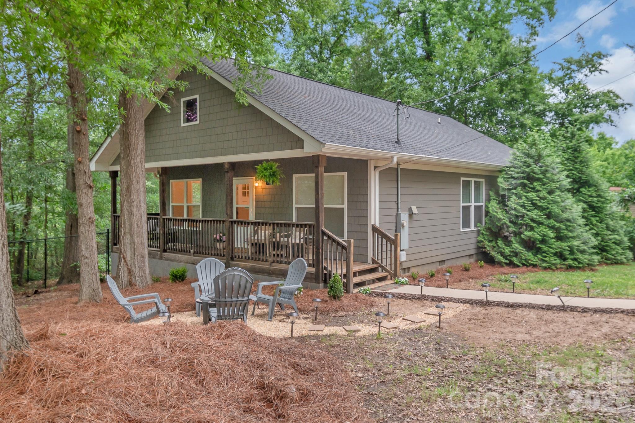 Welcome to this charming 3-bedroom, 2-bath cottage offering modern comfort and an ideal Monroe location. Built in 2018, this move-in ready home features an open-concept design with a dining room that flows seamlessly into the living room, complete with custom built-in bookshelves and an electric fireplace. The kitchen offers granite countertops, ample cabinetry, and plenty of prep space. Enjoy outdoor living from the oversized rocking-chair front porch, fenced side yard, and inviting firepit area. Conveniently located just minutes from Monroe's historic downtown, local shopping, restaurants, entertainment, and Hwy 74. Dickerson Park is just beyond the wooded backdrop, providing easy access to outdoor recreation. A wonderful combination of charm, convenience, and low-maintenance living.