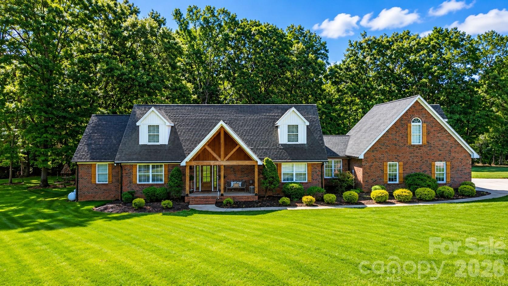 In today's market, three features consistently top buyers' wish lists: a pool, abundant garage space, and flexibility for multigenerational living. This Lincolnton property delivers all three while offering convenient access to both Hickory and Charlotte.

Designed to adapt to a variety of living arrangements, this spacious home offers 3 bedrooms, 3 full baths, a huge 22x16 bonus room, and multiple flex spaces that can easily serve as home offices, exercise rooms, craft rooms, hobby areas, or guest accommodations. The main level features a spacious primary suite with double closets, dual vanities, an oversized shower, and a soaking tub. An additional main-level room located near a full bath creates an excellent option for guests, extended family, or those seeking to minimize stairs.

The floor plan continues upstairs with two bedrooms, a full bath, and separate living areas that provide flexibility for recreation, work, or everyday living. An oversized garage accommodates larger vehicles, while a bright secondary entrance adds everyday convenience.

Outside is where this property truly sets itself apart. The beautifully treed lot features an inground pool with diving board, generous poolside gathering space, a covered deck built for entertaining, and an activity court ready for basketball, pickleball, or tennis. A 2,200-square-foot detached building brings total garage and workshop space to nearly 3,000 square feet, creating endless possibilities for storage, hobbies, equipment, vehicles, or recreational toys.