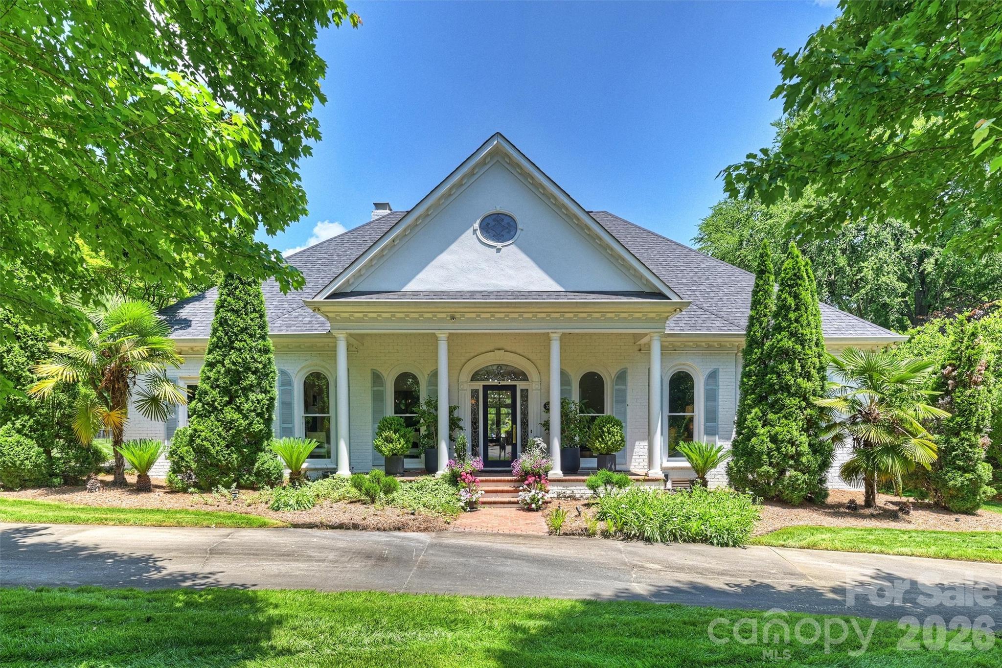 Elegant custom home on a beautifully landscaped 1+ acre lot in highly desirable Royden! This 5,424 SF home blends warmth, functionality and timeless character. The welcoming floor plan features a private office just off the entry and a formal dining room. French doors lead to a spacious great room with a stunning stone fireplace, built-ins and a wet bar with mirrored accents. Large windows and doors open to a screened porch overlooking the landscaped backyard and pool area. The chef’s kitchen features a gas cooktop, mirrored backsplash, wine refrigerator and custom glass front cabinetry with a laundry room and pantry located steps away. The main level primary suite is a peaceful retreat with direct access to the screened porch. Enjoy serene views of the climbing roses and gunite pool while listening to soothing water sounds from decorative wall fountains. Dual walk-in closets and a nearby cedar closet provide additional storage. An expansive guest bedroom with en-suite bath and walk-in closet is also located on the main floor. Upstairs are two generously sized bedrooms and a large recreational space. This bonus area is perfect for a personal gym, playroom or artist’s studio due to the natural light. Large walk-in attic offers future expansion potential. Royden is conveniently located near Carmel Country Club, SouthPark premier shopping and many dining establishments.