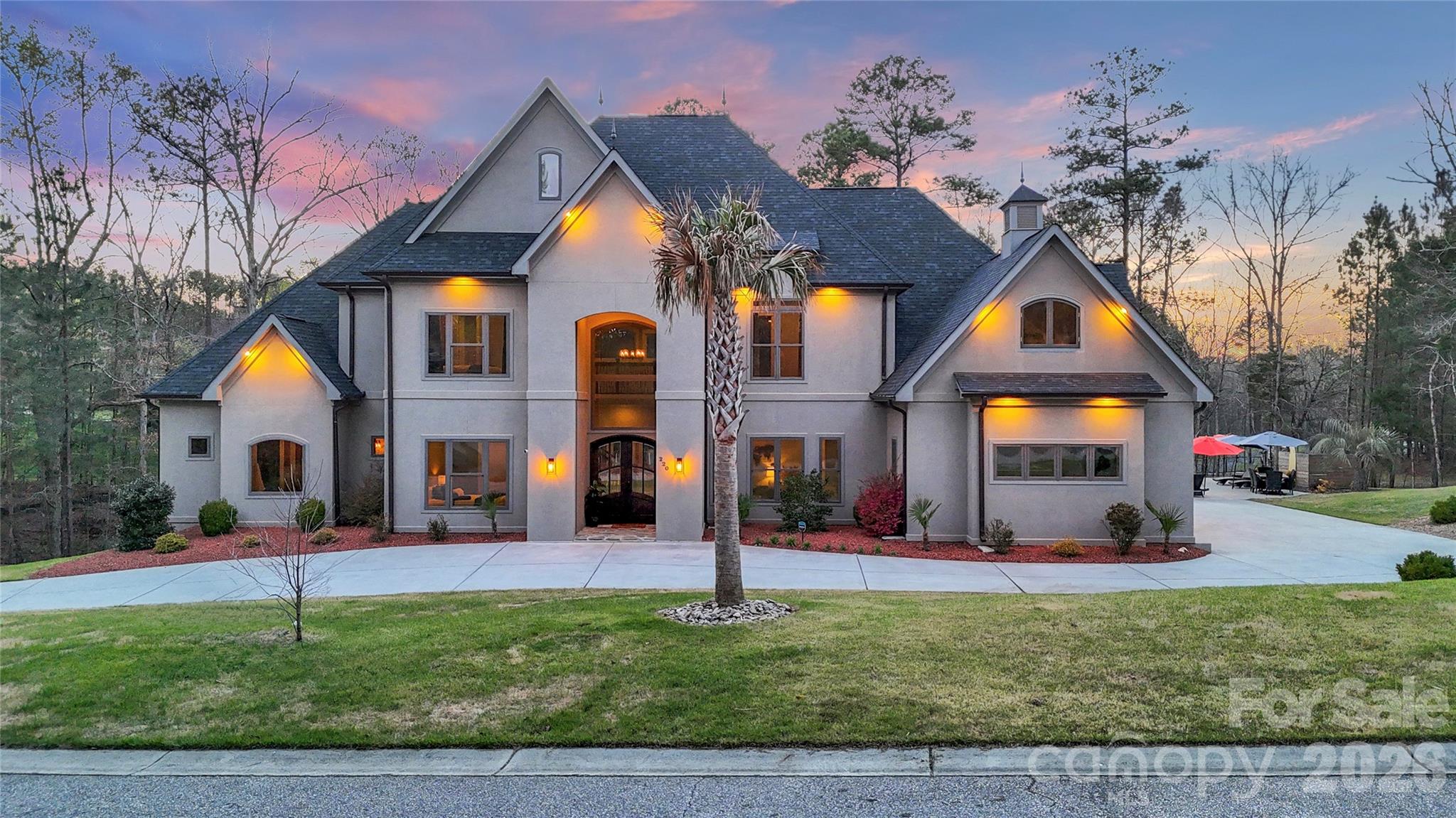 Welcome to 220 Palm Cove Way, a stunning custom-built estate nestled in the highly sought-after Palm Tree Cove community on Lake Wylie’s Allison Creek Peninsula. This exceptional 5-bedroom, 5.5-bathroom home offers over 5,000 square feet of refined living, showcasing soaring ceilings, an expansive open layout, and designer finishes throughout. Situated on more than an acre within the award-winning Clover School District, this property is the perfect blend of elegance and comfort. The chef’s kitchen is a true centerpiece, featuring a 48-inch gas range with split oven, built-in refrigerator, wall oven, and microwave-enhanced by both a spacious butler’s pantry and a walk-in pantry, providing abundant storage and seamless functionality for effortless entertaining. Step outside to your private resort-style oasis, complete with a pool and spa, or enjoy the convenience of a 900+ square foot climate-controlled three-car garage. Thoughtfully designed with timeless craftsmanship and generous living spaces, this home offers both sophistication and functionality.Experience the best of Lake Wylie living with serene surroundings, a welcoming community atmosphere, and easy access to Allison Creek Park, including camping and a public boat launch. This is a rare opportunity to own a luxurious lakeside retreat.