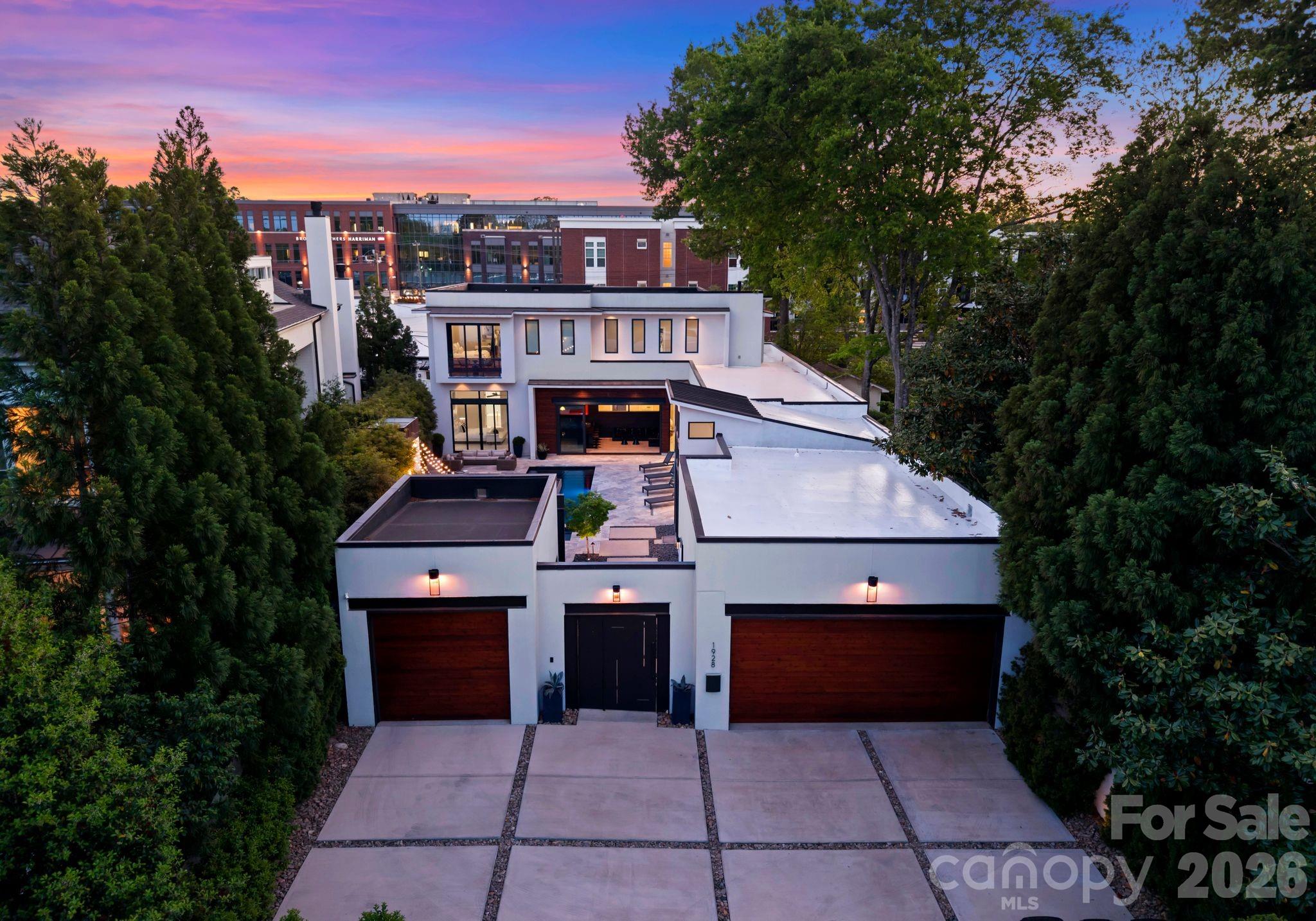 Welcome to your stunning penthouse style home in the heart of Charlotte’s coveted Elizabeth neighborhood, where modern luxury meets seamless indoor/outdoor living. A custom steel pivot door opens to a private courtyard retreat, complete with a louvered pergola, Belforno pizza oven, grilling station and year round entertainment room, perfectly designed for hosting guests. A rear turf yard and sport court further enhance the home’s unique appeal. Inside, a light filled open floor plan with soaring ceilings showcases a chef’s kitchen featuring premium Miele appliances, inviting dining area, and expansive great room. A dramatic wall of windows and sliding glass doors seamlessly connects the interior to the courtyard, creating an exceptional entertaining experience.
The private main level primary suite offers a true retreat, complete with a spa inspired bath featuring dual vanities, a glass enclosed shower, steam room, and an Italian designed custom walk-in closet. Two additional guest suites complete the main level. Reclaimed wood wall and glass staircase leads to the upper level, where you’ll find two additional guest suites, a home theater (that includes dolby surround sound, projector and screen) and access to the walkout roof deck to soak in stunning sunsets and city views for days! This home is walkable to some of the area’s favorite restaurants and shops in Elizabeth and Plaza Midwood area.