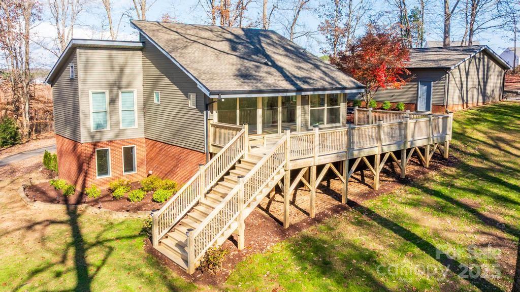 RUN don't walk...LOOKING for a large lot, no HOA & privacy? Look no further! Check out this charming fully updated contemporary home on 2.35 total acres in Sherrills Ford, including Parcel #460904824173 (Lot 7 – 1.08 acres) and Parcel #460904815969 (Lot 6 – 1.27 acres) in the Lynmore Subdivision. The property features tall vaulted ceilings, an open floor plan, TONS of natural lighting & walls of windows. And ALSO a 973 SQ. FT. Detached, air conditioned,  two-car garage plus a large shed, a large newly built deck, & a partially cleared second lot—ideal for PRIVACY, a play area, garden, or future outdoor use. The garage offers flexibility for a workshop or additional recreational space.
The main level offers a spacious a Great Room with vaulted ceilings, an updated kitchen with breakfast nook. A wall of windows overlooks the mature landscape. The lower level provides additional living space with a full bath, bedroom and flex areas perfect for an office, gym, or recreation room. A storage building, paved driveway, and extra parking complete this property. New roof in 2023, HVAC 2023 & septic Tank in 2023. Conveniently located near the new Publix, shops & restaurants. Includes a BUYER HOME WARRANTY. HURRY this rare gem & spectacular opportunity WILL NOT LAST LONG!