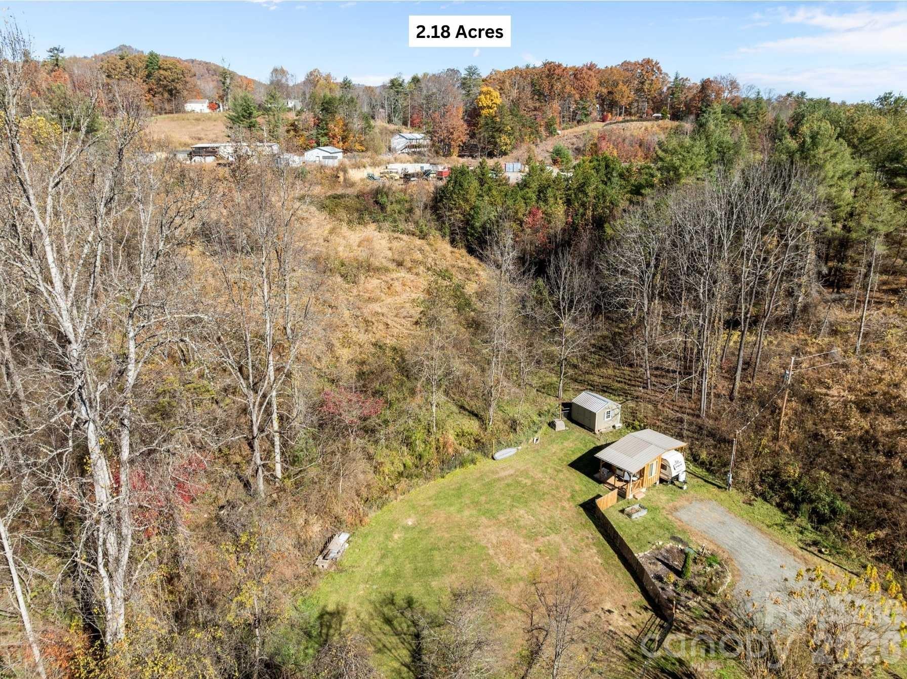 Ready-to-build 2.18-acre property that is peaceful, private, and convenient within minutes of Mars Hill. The land is thoughtfully prepared and waiting for your dream home or getaway cabin. All the essentials are already in place: a new well and 2-bedroom septic system (installed in 2024), along with electric service from French Broad Electric also offering reliable, high-speed internet - perfect for remote work or streaming.
A private drive provides easy access to the property, where approximately half an acre is cleared and build-ready. The fenced yard includes a room and porch structure - ideal as a workshop, studio, or temporary shelter while you build. A gentle knoll offers potential for a second build site. The property features both a spring-fed creek and a wet-weather creek, creating a serene natural setting filled with abundant wildlife.