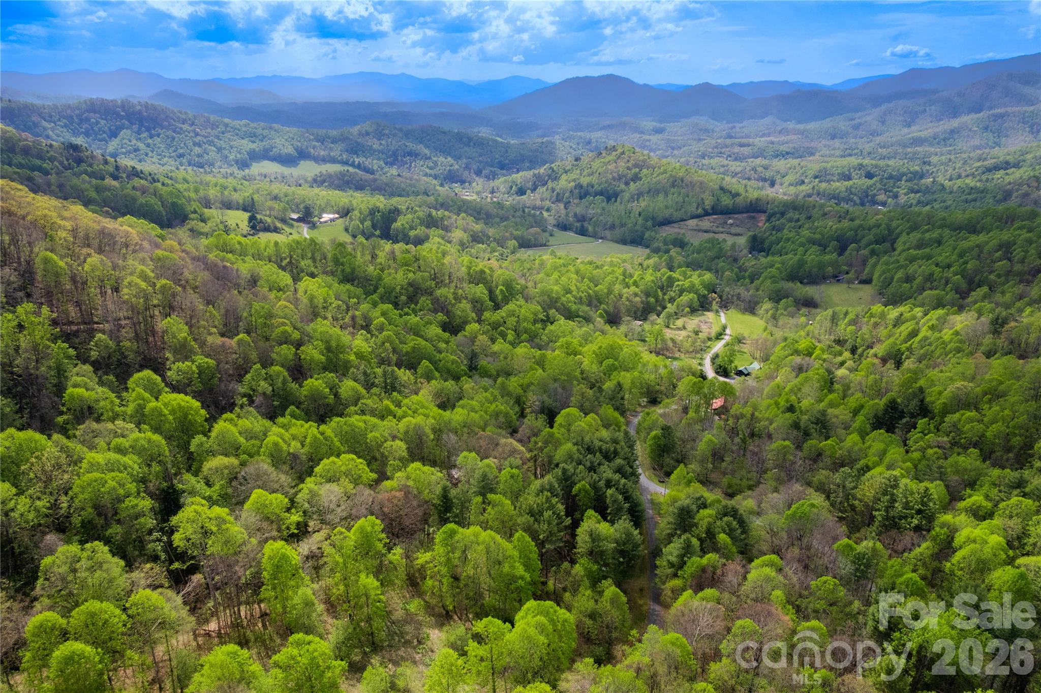 FRESHLY RE-PRICED!  Private 2.04 +/- acre mountain property near Bakersville NC, with an existing well already installed -- ideal for camping now and building your mountain getaway later!  This homesite is in the desirable Orchard at Greene Cove community. Lot #13 Apple Farm Rd offers privacy, gentle terrain, and potential long-range mountain views with selective clearing. Major improvements already completed, including a documented 15 GPM private well, power at the lot, previously approved 3-bedroom septic permit, installed culvert/access, and house plans included at no additional cost. The property borders headwaters of Green Cove Creek, with adjacent land across the creek expected to become conservancy land, creating a rare “forever wild” setting. Community covenants allow limited camping/RV to use up to 4 consecutive weeks at a time and up to 12 total weeks per year, allowing you to enjoy the property during the hot summer months while planning your future mountain home. The subdivision's site-built homes only help protect long-term property values. Convenient to the Blue Ridge Parkway, Appalachian Trail, Toe River, Bakersville, Spruce Pine, Burnsville, Asheville, and Johnson City, TN. Wildlife, cool mountain breezes, and dark star-filled skies complete the experience. Rare opportunity to own improved mountain land that is ready to enjoy now and build later.