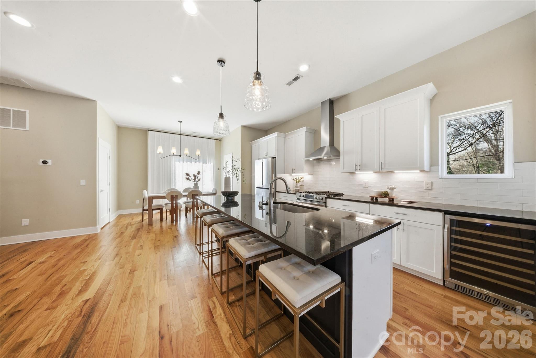 Welcome home to 1602 Julia Maulden Place, where rooftop city views, walkable urban living, and thoughtfully crafted luxury design come together in one of Charlotte's most energetic neighborhoods. Steps from Optimist Hall, Bird Pizzeria, Little Sugar Creek Greenway, and the Parkwood Light Rail Station, this is Charlotte urban living at its most connected.

Even with a modern open concept design and over 2,900 square feet of living space, the crown jewel of this residence is nearly 900 square feet of private rooftop terrace. Finished with turf, equipped with a propane fire pit, and plumbed for a gas grill and sink while all framed by sweeping views of the Charlotte skyline. This outdoor space is unmatched at this price point.

The main level is designed for effortless entertaining. A fully open kitchen, dining, and living area anchors the floor, fitted with high-end appliances and beautiful hardwood floors. A massive multi-panel sliding door dissolves the boundary between the living space and the side porch, creating true indoor-outdoor flow. A powder bath and dedicated laundry room completes this level.

The third floor offers a spacious primary suite with a walk-in closet and generous storage, plus a second bedroom with its own ensuite bathroom. Hardwood floors continue throughout this third floor. The entry level sets the tone from the moment you arrive. The finished two-car garage is complete with a dedicated EV charger. The rest of the entry floor features a drop zone and a flexible bedroom with a full bath.

Throughout the home, Lutron smart switches provide seamless lighting control, and an automated irrigation system keeps the landscaped, fenced yard effortlessly maintained.