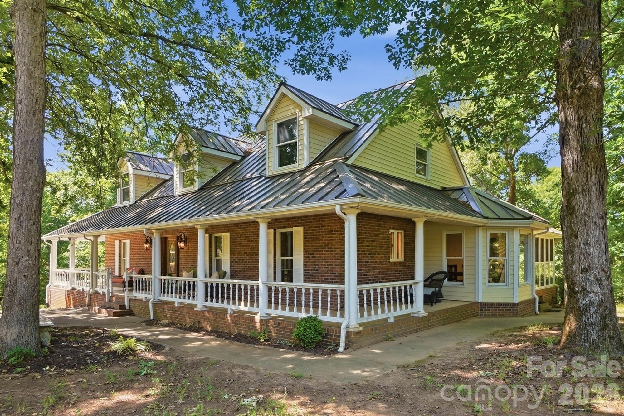 Welcome to 846 Windy Oaks Way - a custom-built brick farmhouse nestled on 15.10 picturesque acres in the charming Town of Van Wyck. This private estate offers the perfect blend of peaceful country living and convenience. Bring your horses, goats, cows, and chickens - the property is ideal for a mini farm or equestrian lifestyle, complete with a barn featuring horse stalls, storage space, and room to park your tractor. The beautiful acreage includes open pastureland, a small pond, and a stream, all tucked away at the end of a private drive where you won’t see or hear neighbors. A charming wrap-around porch welcomes you home. Inside, the foyer opens to a stunning two-story great room with a brick fireplace and lots of natural light. The spacious kitchen features custom cabinets, granite countertops, and opens to a large dining area - perfect for gatherings and everyday living. The main-level primary suite includes plantation shutters, a large walk-in closet, and a bath with a claw-foot tub. A dedicated office with French doors sits just off the foyer, while the main level laundry/mud room and half bath add everyday convenience. The sunroom is sure to become a favorite spot to relax and enjoy the peaceful surroundings. The finished basement offers versatility with a large Rec room with a brick fireplace, pool table area, full bath, and multiple flex rooms ideal for offices, hobbies, crafts, or workout space. Outdoor living features an in-ground pool, multiple seating areas, outdoor fireplace, built-in grill, and pizza oven - creating the perfect setting for entertaining or simply enjoying the quiet beauty of the property. Located in desirable Van Wyck, this premier location offers the tranquility of country living while remaining conveniently close to Indian Land, Lancaster, Waxhaw, Rock Hill, South Charlotte, and I-77. This beautiful property has incredible potential and is ready for your personal updates and finishing touches. Please do not walk the property without an appointment.