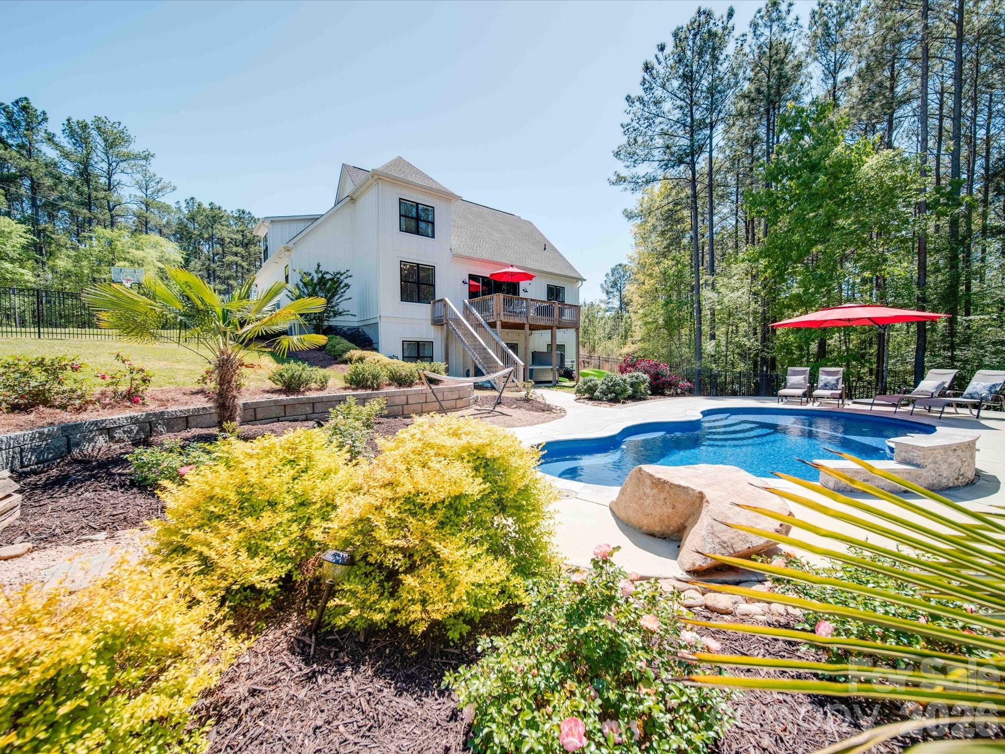 Turnkey, cash-flowing Lake Wylie waterfront short-term rental offered fully furnished with no HOA! Professionally managed and actively operating, this 2021-built modern farmhouse has generated strong annual STR revenue with bookings already on calendar through September 2026. Primary suite on main opens to an expansive open-concept great room and chef's kitchen with island. Three additional bedrooms upstairs share a full bath. The fully finished walk-out basement delivers the entertainment experience that drives STR demand — home theatre, game room, recreation room, bunk room sleeping space, and full bath — with direct walkout access to a saltwater pool, covered hot tub, fire pit, and rear deck overlooking Lake Wylie year-round. Fiber cement exterior with modern systems throughout. Fully-fenced backyard with private walking path to Lake Wylie to launch your kayaks — not dockable but near Allison Creek Park for boat ramp access and much more. Step in and start generating revenue from day one!