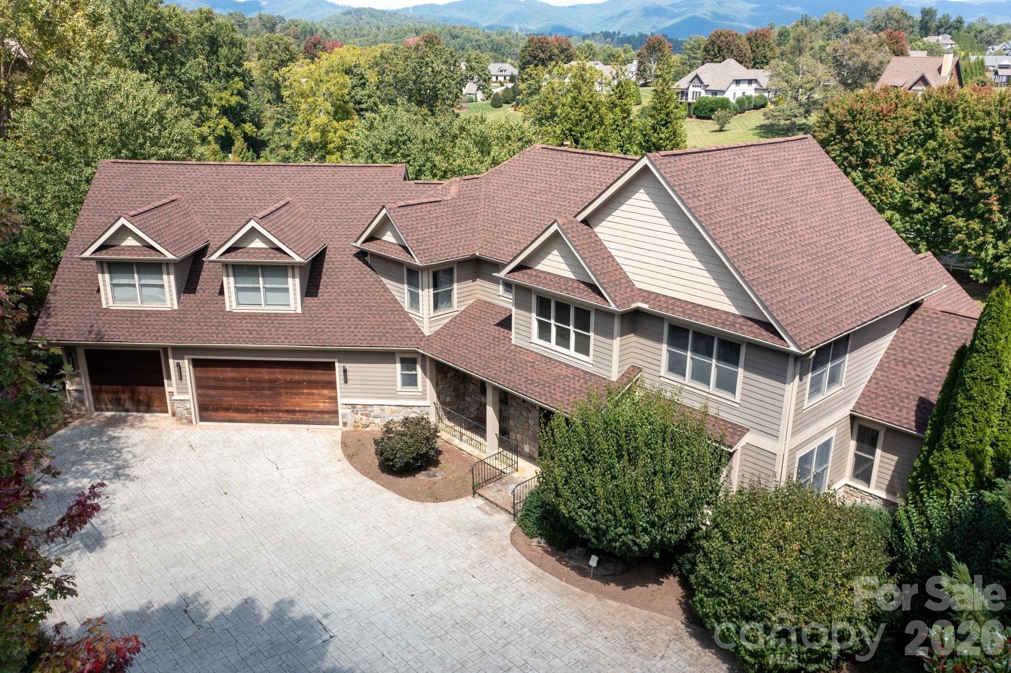 Welcome to Waterford Lakes, one of Fletcher’s most desirable communities, perfectly positioned between Asheville and Hendersonville. This established neighborhood offers a balance of convenience and mountain living, with scenic walking trails, views of the Blue Ridge Mountains, and rolling pastureland with horses in the backdrop. Remodeled in 2019 by Tyner Construction, this spacious home blends modern updates with timeless style. The airy open floor plan features a main-level primary suite with a one of kind custom walk-in closet and spa-like bath. The chef’s kitchen boasts premium appliances, walk-in pantry, stylish finishes, and seamless flow for everyday living and entertaining. Upstairs, you’ll find three spacious bedrooms, three full baths, and a large bonus room ideal for flex space, office, or playroom. The finished basement adds versatility with two bonus rooms, a workout area, a full bath, and an expansive media room with a kitchenette—perfect for multi-generational living or large gatherings. Enjoy outdoor living with multiple decks showcasing stunning mountain views, a sparkling pool, and a fire pit patio designed for fun. A 3-car garage provides ample space for vehicles, storage, and hobbies. City water, no city taxes, and highly regarded school districts (Fairview Elementary, Cane Creek Middle, A.C. Reynolds High) complete the package. Less than 15 miles from Asheville Regional Airport, Mission Hospital, Advent Hospital, Downtown Asheville, Biltmore House, and the Blue Ridge Parkway. Don’t miss this exceptional home offering luxury, comfort, and lifestyle in one of the areas premier communities.