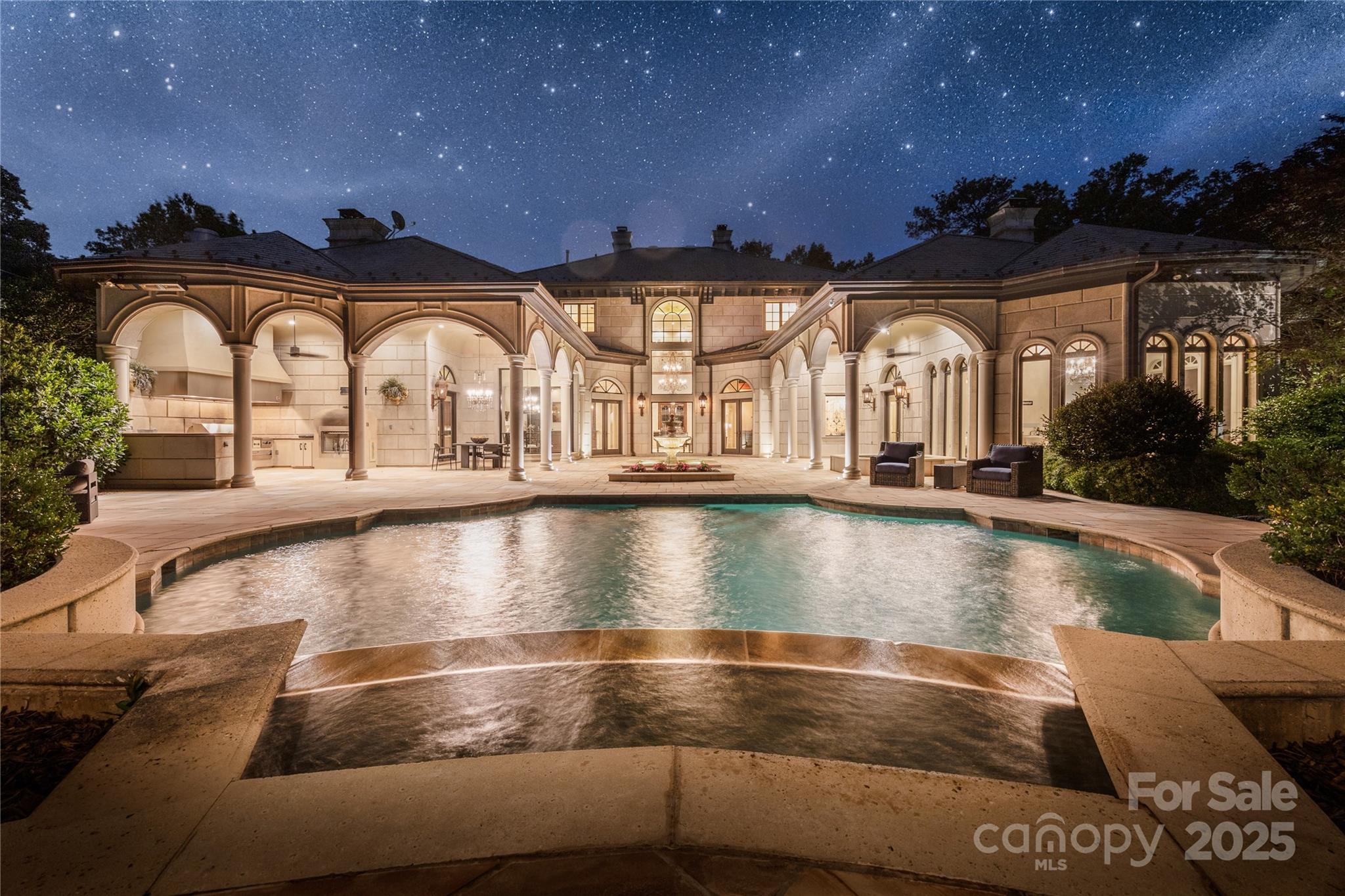 Indulge in the ultimate luxury living experience, where timeless elegance meets modern sophistication. Outside, immerse yourself in a beautifully designed landscape adorned with formal gardens and enchanting trellised walkways—each corner beckoning for moments of tranquility and joy. Imagine gathering around the inviting gas log fire pit, or retreating to the atmospheric glow of gas lanterns as you unwind in the lavish spa. Experience truly unforgettable evenings with al fresco dining in your serene grilling area, thoughtfully equipped with custom heaters, a cozy gas fireplace, cooling fans, and a dazzling chandelier that creates an idyllic ambiance for relaxation and connection. The primary en-suite is a wellness sanctuary, featuring a luxurious spa/exercise room with a steam shower and massage area, a sumptuous garden tub, and a serene waterfall.