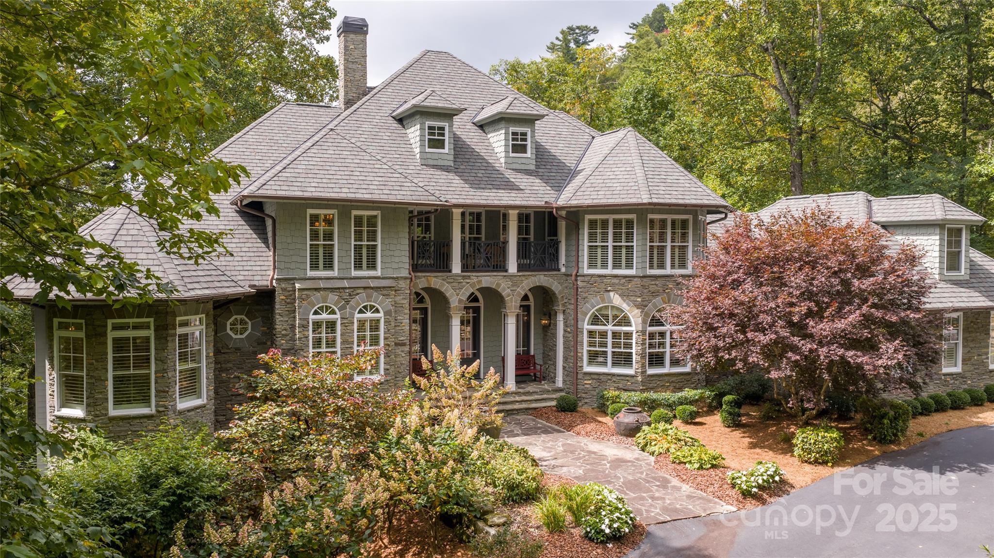 This estate property blends timeless architecture and a versatile floor plan suitable for privacy and/or entertaining on a grand scale. Perched on a private lot in Highlands Falls Country Club, one of area’s most sought-after communities, the home features a two-story stone fireplace, coffered ceilings, a formal dining room, and a chef's kitchen with professional appliances that opens to a bright family room with an adjacent covered and heated porch. Additional highlights of the main level include an expansive primary suite, an office with a limestone fireplace, and a spacious laundry room. Upstairs are three guest bedrooms, each featuring a walk-in closet, ensuite baths, and private porches. Additional features include a multi-room, cedar-lined walk-in attic, encapsulated basement, rare three-car garage, and gorgeous grounds. Offered luxuriously furnished with minor exclusions. This property has been meticulously maintained with recent updates including, new roof with a 50-year transferable limited warranty, three (3) new HVAC systems, two (2) new hot water heaters and a Generac generator. Membership to Highlands Falls Country Club is not mandatory, but the amenities are legendary, and the environment is warm and welcoming. Highlands NC was selected by Travel & Leisure as “America’s Best Small Mountain Town” in 2023 and Outside magazine ranked Highlands as one of its top ten small adventure towns in the world for 2026.