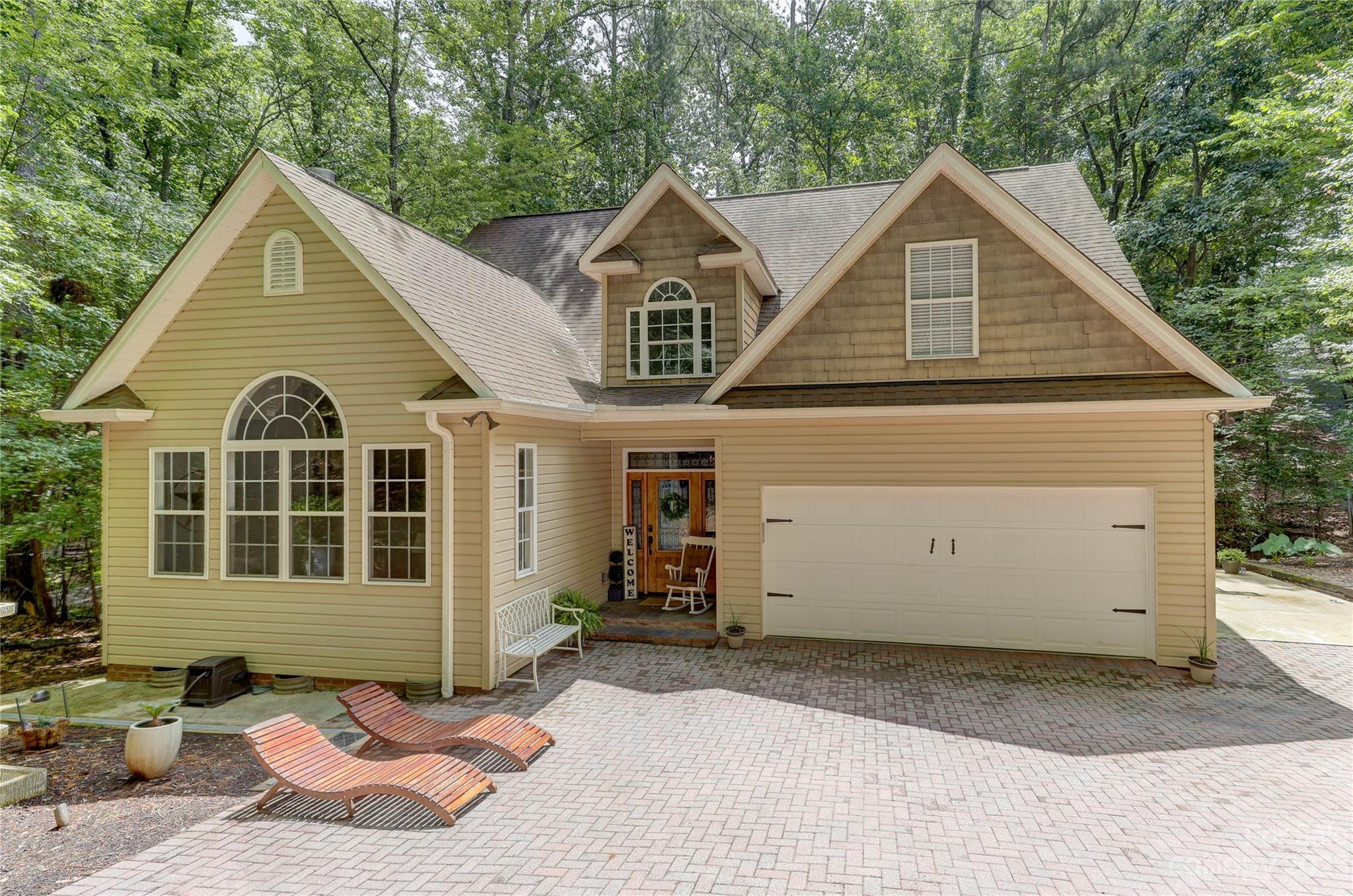Outdoor & water lovers prepare to be impressed! With year round water views, this sought after customized Tega Cay home has tons of curb appeal & upgraded features to make this home feel warm & inviting. Situated in a quiet cul-de-sac lot w/a gorgeous brick paver driveway & professionally installed landscape lighting. And that’s just in front! In the back of the home, the oversized deck leads to a brick patio with fire pit, sitting walls, & those amazing views. Add'l interior features include wood floors, newer paint, an updated kitchen w/ss appliances, granite countertops, primary suite on the main level, 4 spacious bdrms upstairs w/one that could serve as a 2nd primary suite. Tons of storage in the attic, garage, walk-in crawl space. Within a short walk to the golf course, clubhouse & restaurant, this community also features a marina w/boat landing. If you enjoy outdoor water activities including summer concerts, kayaking, boating, golfing & so much more, this is the home for you.