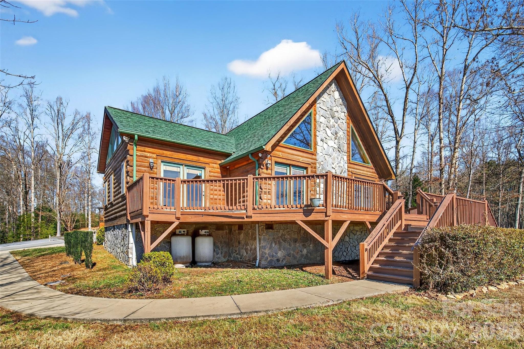 MAJOR PRICE IMPROVEMENT! Been looking for a classic mountain log cabin without the maintenance? Wanting a getaway that's still convenient to town, a gorgeous lake and two of NC's best cities? Well, you found it. This one-owner, well-maintained rustic charmer has so much to love: a brand new roof, 3 large bedrooms each with their own attached bath, a stunning floor-to-ceiling gas fireplace, decks all around, 4-inch oak floors, custom molding and trim throughout, stainless steel appliances, Corian countertops and a huge detached garage complete with its own finished (no HVAC currently) space above the parking area. Use it as a workout room, abundant storage, art studio, additional guest quarters - so many possibilities. Need a primary home? The convenience to I-40, Lake James and its state park, the town of Marion and the amazing cities of Asheville (45 min) and Charlotte (90 minutes) make that totally feasible. Need a vacation home that helps pay for itself? She can do that too! Short-term rentals (AirBNB & VRBO) are allowed! Tucked just inside a lovely small gated community, enjoy the benefits of security, a community pool and friendly neighbors all with low HOA fees. A solid, warm and inviting property, she is move-in ready. Bring your own warmth and love - and let's make her a home again. NOTE: this home faces a two-lane rural road/highway; it is visible from the home.