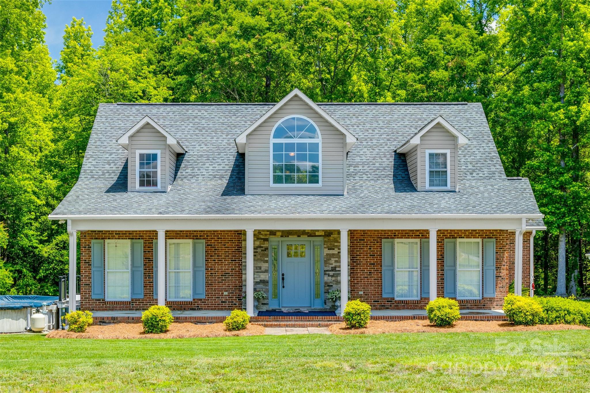 Gorgeous brick 1.5 story home on 5 acres with a 658 square foot guest house nestled in the woods! The main house boasts a beautifully updated kitchen with white cabinets, a backsplash, and granite countertops. The spacious family room leads to a cozy sunroom with white painted brick. Upstairs, you'll find 2 bedrooms and a bonus room featuring new gray vinyl plank floors, a remodeled bathroom, and ample storage. Enjoy the outdoors with a tree-lined backyard, a Trex deck, and a screened-in porch that opens to an above-ground pool with a new cover. The guest house, nestled in the woods, includes a living area, kitchenette with a gas cooktop, bedroom, and full bathroom. The detached garage and carport provide ample space for your vehicles and outdoor gear!