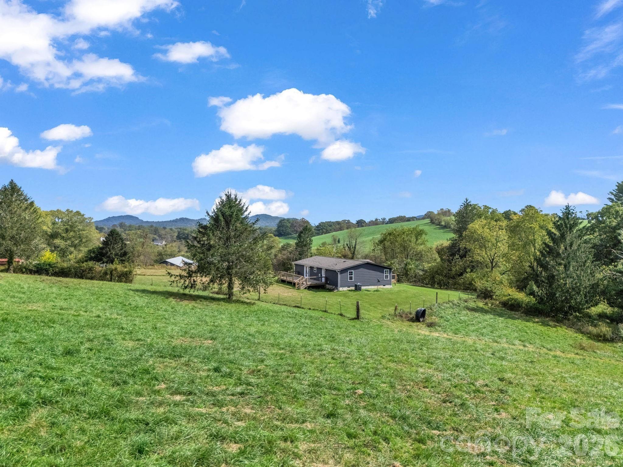 Mills River. 25 acres ideally situated and convenient to Asheville, Hendersonville, and Brevard. Only minutes away from the national forest, breweries, shopping and dining. Whether you enjoy hiking, horseback riding, mountain, biking, or camping you will love this peaceful location. Live in the existing home or build your dream home. Three-bedroom two-bath home is move-in ready with new paint inside and out, newer flooring, and decks. It has a three bay workshop/barn. Grading has been completed for building another home and barn. You will be impressed with the incredible views in every direction. This is a hunting and fishing paradise with abundant wildlife in the lush meadows and woods. Currently on a shared well, but water rights will not transfer. New well must be drilled.