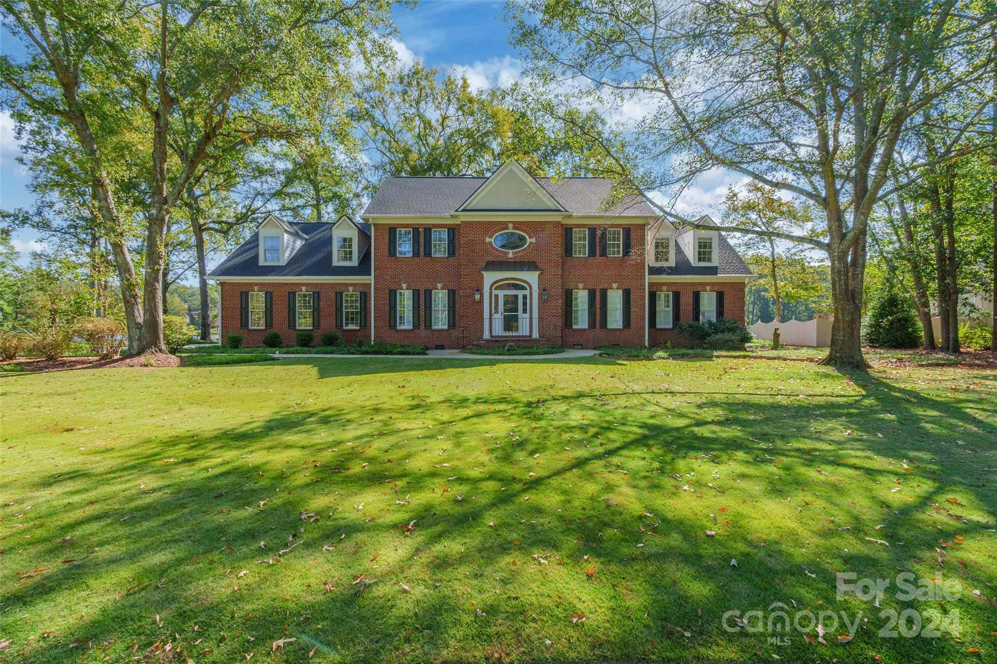 Nestled in the desirable Meadow Lakes, this stunning all-brick home exudes elegance and comfort. Step into the grand two-story foyer, where beautiful refinished hardwood floors flow through the main living areas. The great room features a cozy brick gas log fireplace, built-ins, transom windows, and a set of double doors leading to a fenced brick patio with serene lake views. The kitchen is a chef's dream, boasting stainless steel appliances, a charming barn sink, a spacious walk-in pantry, and quartz countertops. The main-level primary suite offers walk-in closets and a spa-like ensuite with a jetted tub. Upstairs, discover five additional bedrooms with two Jack & Jill bathrooms and a versatile bonus room. Recent updates include a new roof, newer HVAC systems, fresh paint, new carpet, and updated baths. Enjoy the flat lot overlooking the lake and the fantastic community amenities, including a clubhouse and tennis courts. This remarkable home is a true gem that you won't want to miss!