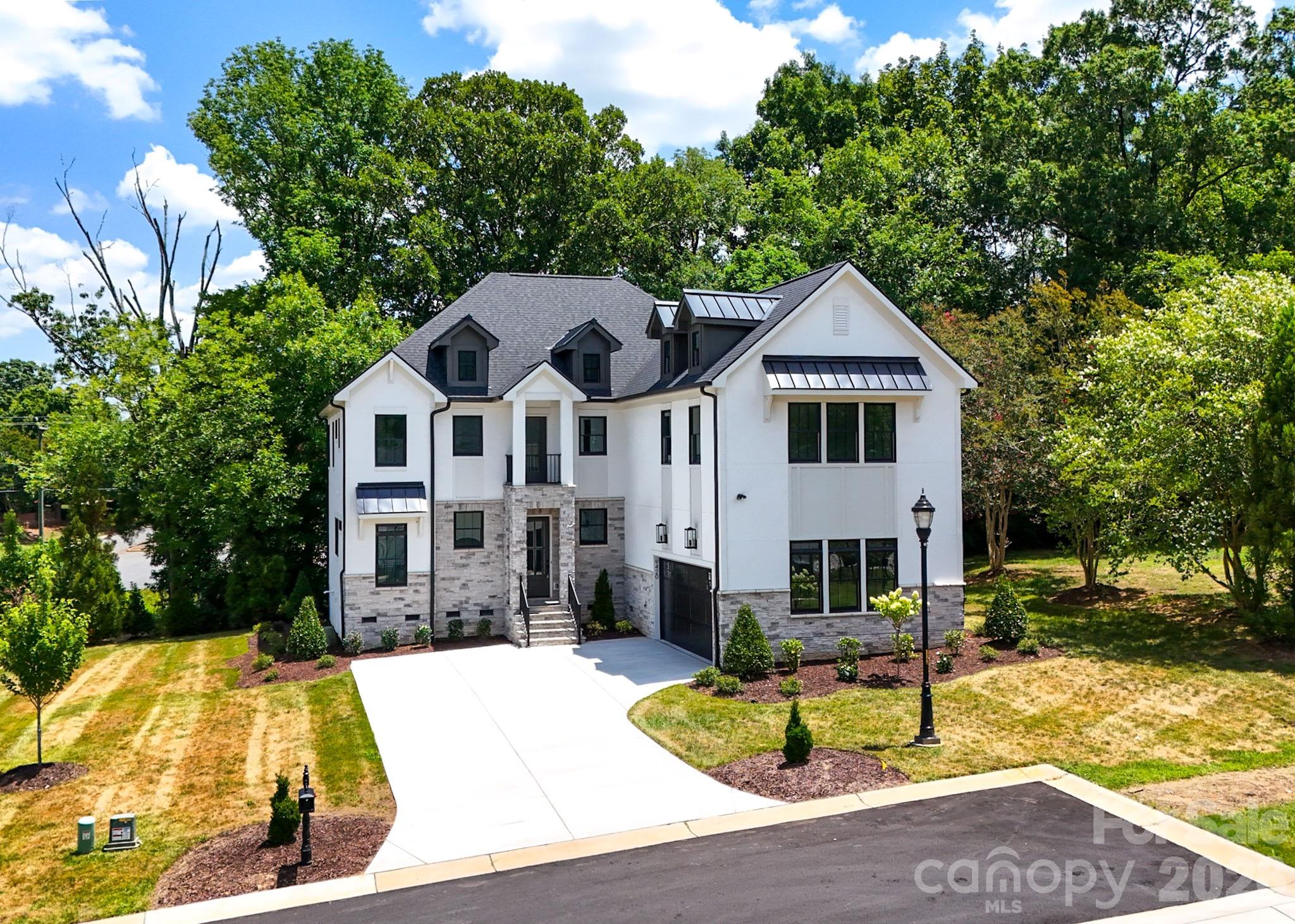 Discover this luxury custom spec home showcasing exceptional craftsmanship and modern design throughout. Built with Anderson 400 Series windows, the home is filled with natural light and framed by premium finishes, including high-end laminate flooring and an elegant, sleek stairwell that creates a striking architectural centerpiece.

Enjoy multiple outdoor living spaces with a walk-out balcony, perfect for morning coffee, and a back deck overlooking a serene, tree-filled setting. The property also features a two-car garage and sits within a cozy, tucked-away subdivision surrounded by nature.

The modern two-tone kitchen is a showpiece, offering luxury quartz countertops, a full quartz backsplash, and beautiful designer light fixtures. French doors lead to a private office and a versatile bonus room, providing flexible space for work or leisure.

Additional highlights include a well-appointed mud room, and a laundry room complete with a sink and generous cabinet storage , stone wall feature with shelves, could be used for wine storage / display.
Located in a highly sought-after area near award-winning golf courses, Charlotte Latin School, and premier shopping and dining, this home blends luxury living with unmatched convenience.
