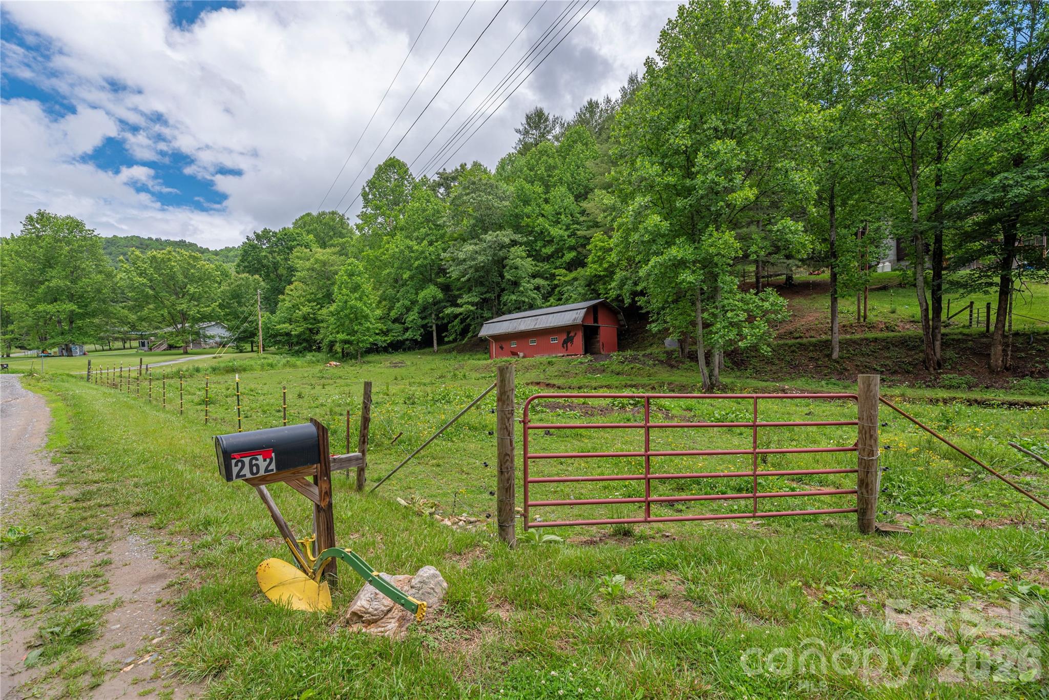 Welcome home to your own slice of Western North Carolina paradise. Nestled on 10.63 unrestricted acres, this authentic log home offers the perfect blend of mountain charm, privacy, and country living. Whether you're dreaming of a horse property, mini-farm, family retreat, hunting getaway, or simply a place to escape the hustle and bustle, this property offers the freedom and space to make it your own. Built in 1984, the 1.5-story home features 3 bedrooms, 2 bathrooms, and 1,924 square feet of warm, inviting living space filled with rustic character. Step inside to discover soaring ceilings, exposed beams, rich wood finishes, and a stunning floor-to-ceiling stone fireplace that serves as the heart of the home. The open-concept living, dining, and kitchen areas create an ideal setting for gathering with family and friends, while large windows bring the beauty of the outdoors inside. The spacious kitchen offers butcher block countertops, stainless steel appliances, abundant cabinetry, and a large island perfect for meal preparation, entertaining, or casual dining. Upstairs, a loft overlooks the great room below and provides flexible space for a home office, recreation room, play area, reading nook, or additional living space. Outside is where this property truly shines. Horse lovers will appreciate the 3-stall horse barn and acreage that provides room for riding, grazing, and enjoying the equestrian lifestyle. The unrestricted land opens the door to countless possibilities, whether you're interested in farming, gardening, raising animals, recreational use, or simply enjoying the peace and privacy of your own mountain retreat. Adding to the property's natural beauty, a creek meanders along the lower boundary, creating a peaceful setting where you can relax to the sound of flowing water and enjoy the sights and sounds of nature. Spend your days exploring your own acreage, watching wildlife, riding horses, gardening, or gathering around a fire under the stars. The unfinished basement provides extensive storage, workshop space, and room for future expansion. Whether you need space for tools, equipment, outdoor gear, hobbies, or envision additional finished square footage in the future, the possibilities are endless. Properties offering unrestricted acreage, a horse barn, creek frontage, and the timeless appeal of a true log home are becoming increasingly difficult to find. This unique mountain property combines rustic charm, functionality, privacy, and natural beauty into one exceptional opportunity. Bring the horses, bring the chickens, plant the garden, cast a line in the creek, and enjoy the freedom that comes with 10.63 unrestricted acres in the mountains of Western North Carolina.