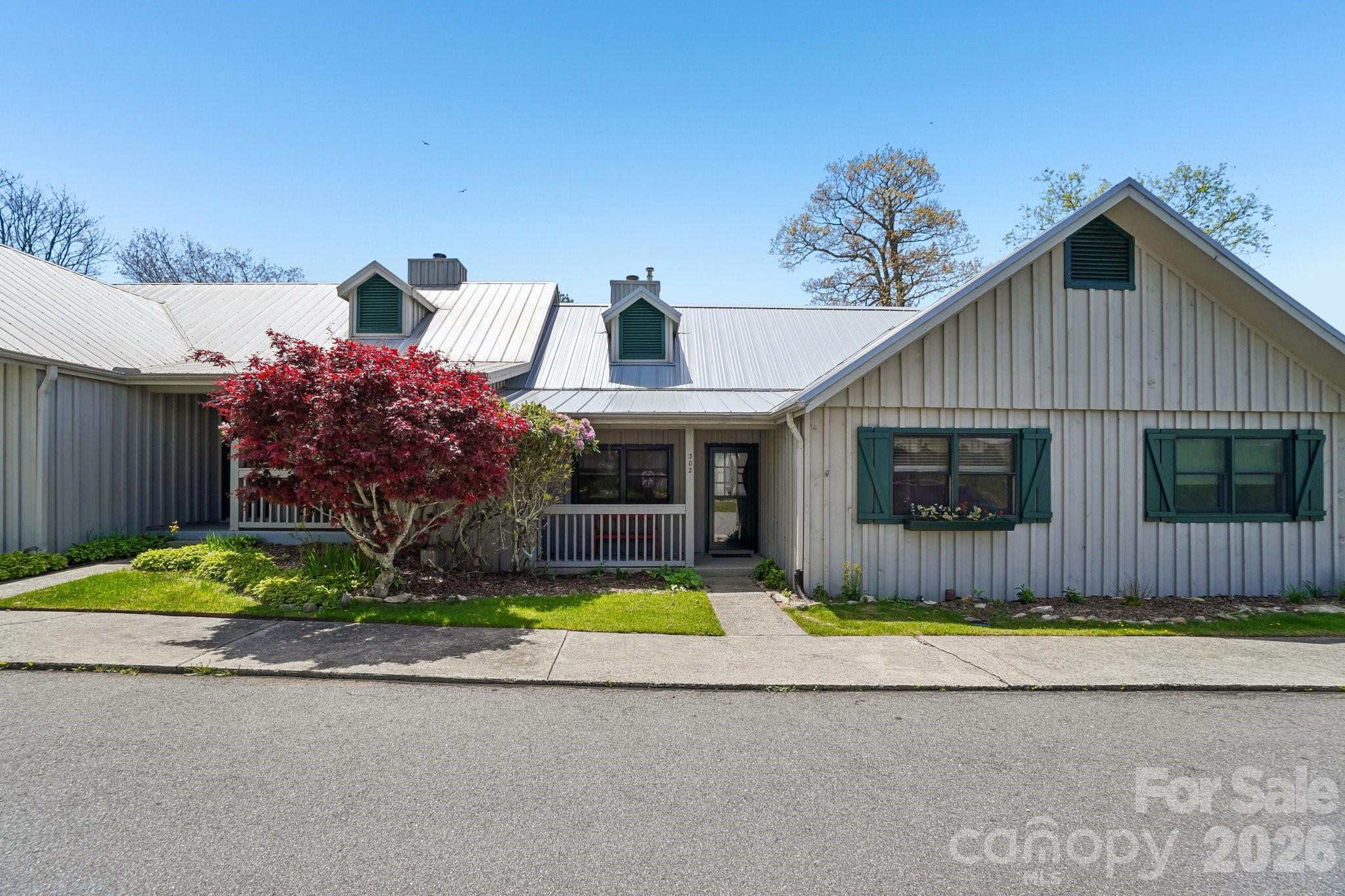 One of the most sought-after locations in Wolf Laurel Community. Walking distance to country club/pro shop, fitness center and walking trails. High elevation and views of 1st tee box, golf course and mountain views. Spacious open floor plan one level townhome with 2 primary suites with cath.ceilings , spacious bedrooms with walk in closets. Great room with wood-burning fireplace, new flooring in hallway and common area/kitchen. tiled bathrooms, one with shower, one with bathtub/shower combo. Large private balcony extended and covered facing south, no direct sunshine on your balcony. Furnished, stainless appliances, kitchen island, granite counters and lots of cabinets. Laundry/pantry area off the kitchen. MOVE IN READY!! COME SEE THIS SPECIAL SPOT TO ESCAPE THE HEAT OR ENJOY WINTER AND SKI SLOPES AND MOUNTAIN BIKING TRAILS AT HATLEY POINTE.