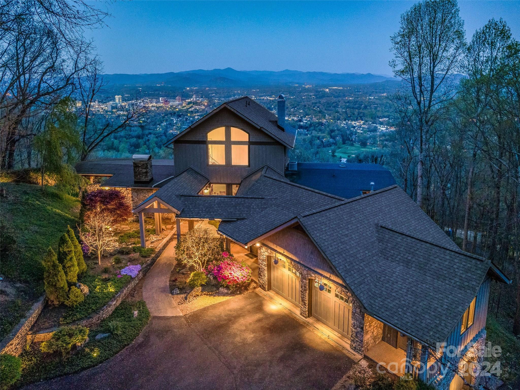 An awe-inspiring property on Sunset Mountain, perched above the city of Asheville with spectacular views of downtown and the majestic mountains beyond. Enjoy 3.4 acres of ultimate privacy in this Tony Lord contemporary, mid-century modern design exquisitely engineered with a traditional touch. In addition to the expansive, stunning views, this attractive mountain home offers luxury living including an incredible, fully-equipped kitchen with an AGA cast iron range, two primary suites, a private guest suite, a screened porch, a four-car garage, and multiple outdoor living and entertaining spaces all framed by gorgeous native stone that seamlessly combines mountain ambience with modern living. Minutes from Downtown, the location and setting make this one of Asheville's most sought-after views, where magical sunsets, soft breezes, and an ever-changing 'big sky' are enjoyed from every room and every glance. A luxury home with these incredible views is rarely available...come see why!
