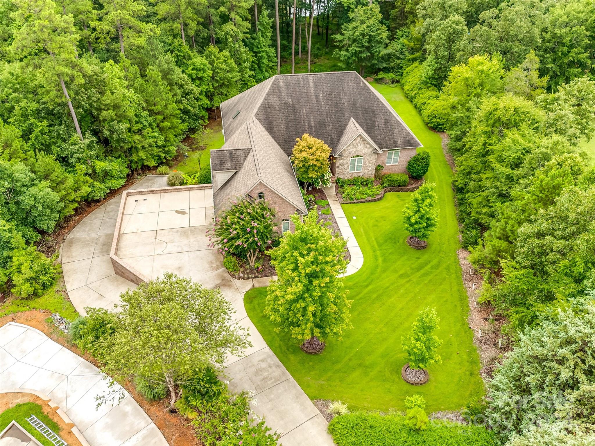 Step inside this wonderful custom home on 1.32 acres with year round water views of Lake Wylie! 4 + car garages. Main floor features stunning brazilian cherry hardwoods, 14 ft tall ceiling in great room w/ handcrafted built-ins, All 3 bedrooms on the main level are very spacious w/ tray ceilings & triple crown moldings. Primary bedroom overlooks the private backyard w/ water views. The bath has a vaulted ceiling w/lots of natural light, massive shower w/ multiple body sprays, walk-thru closet w/ wood shelves & access to the laundry room. Kitchen has stunning granite countertops w/ bar seating, maple cabinets, walk- in pantry, double wall ovens. Breakfast area has a wall of cabinets & additional countertop space. Dining room is just off the kitchen & open to the great room. Office has detailed coffered ceiling w/ heavy moldings. Upstairs - huge bonus room w/ half bath. Basement 2nd living area is wheelchair accessible via 2nd garage, w/ living/rec room, BR, bath. 24 ft x 36 ft workshop!