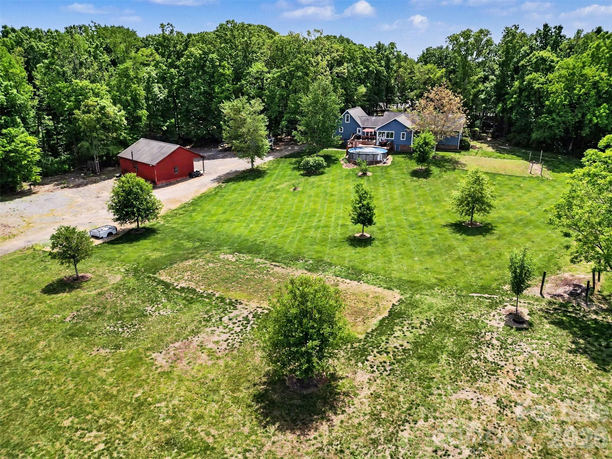 Set on more than six acres in one of Charlotte’s most desirable and rapidly growing development corridors, this exceptional property presents a rare opportunity for investors, builders, developers, or buyers seeking acreage with long-term potential. With zoning that allows for subdivision, the property offers the flexibility to create multiple homesites while enjoying the benefits of an established residence already in place.

The land itself is a standout feature—offering a beautiful blend of open space, mature trees, gently rolling landscape, and privacy rarely found this close to Charlotte conveniences. Existing infrastructure and improvements add immediate value, including city water service to the home, well water supporting irrigation, established landscaping, and multiple usable outdoor structures including a detached barn and charming she shed/studio.

The existing home has been thoughtfully updated and is move-in ready, making it ideal as a primary residence, rental investment, or temporary holding property while future development plans are explored. Features include updated windows, exterior improvements, wood flooring, spacious living areas, and outdoor entertaining spaces overlooking the pool and surrounding acreage.

Located just minutes from Concord Mills, Charlotte Motor Speedway, shopping, dining, and major roadways, this property combines the convenience of a prime Charlotte location with the rarity of substantial acreage and development flexibility. Opportunities of this size and potential in this area are increasingly hard to find.

Whether you envision a private estate, custom home enclave, family compound, or future residential development, this property offers exceptional versatility in a high-demand growth area.Outdoor living is where this property truly stands apart. A large deck overlooks the backyard and pool area, creating the perfect setting for entertaining or relaxing while taking in the surrounding landscape. The acreage itself is both beautiful and functional, with an irrigation system that services the yard and garden areas, supported by well water, while the home is connected to city water for everyday convenience. Established perennial beds, blooming seasonal plantings, and mature fruit offerings—including fig trees and berry patches—create a vibrant, ever-changing landscape.
The property is further enhanced by a charming she shed ideal for a studio or retreat, along with a detached barn that offers flexibility for storage, hobbies, or future use. With over six acres and zoning that allows for subdivision, this is a unique opportunity to enjoy a private estate setting now while preserving long-term potential.
All of this is set in a prime location just minutes from shopping, dining, and everyday conveniences, while still offering the feel of a private retreat. With easy access to major roadways and nearby amenities, the property combines the best of quiet, expansive living with the convenience of being close to everything Charlotte has to offer. 
Outdoor living is where this property truly shines. A large deck overlooks the backyard and pool area, ideal for entertaining or unwinding while taking in the surrounding landscape. The acreage offers a mix of open land and wooded privacy, enhanced by a charming she shed perfect for a studio or quiet retreat, along with a detached barn that adds character and endless possibilities for storage, hobbies, or future use.

With over six acres and zoning that allows for subdivision, this property presents a unique opportunity for future development, investment, or simply enjoying the space as your own private estate. All of this in a prime location with convenient access to Concord Mills Mall, the Charlotte Motor speedway and other Charlotte amenities, making it a truly rare offering.
