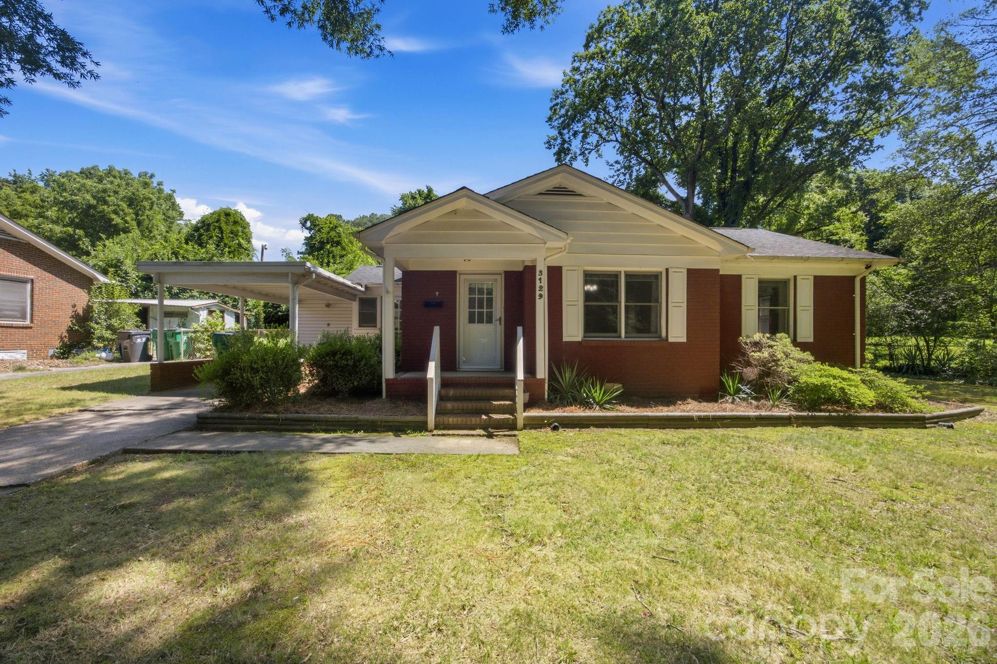 Picture yourself pulling into the driveway on a golden afternoon, the classic red brick of this 1956 charmer glowing warm in the light. There's a solid, timeless feel to a full-brick, one-story home like this one — the kind of place that has stood proudly for decades and is ready to hold decades more of your story.
Step through the full-glass storm door into a bright, welcoming breakfast and kitchen area, where sunlight spills across the space and the day begins. This is the heart of the home — where morning coffee slows down, where the kids do homework at the table while dinner simmers, where friends gather and linger a little longer. There's real room to cook and share here, with the breakfast area inviting you to pull up a chair and settle in.
From there, the living room opens up with gleaming hardwood floors that catch the afternoon light and stretch soft and easy across the room. It's the kind of space that feels instantly like home. The original wood floors carry through into all three bedrooms — each one a quiet, sunlit retreat wrapped in that same warm character, ready for restful nights and lazy weekend mornings. The full bath keeps the home's mid-century soul while feeling fresh and cared for.
But the real magic waits out back. Imagine kicking off your shoes and settling into the large screen porch as a summer evening cools — no bugs, just the breeze, a good book, and the gentle hum of the neighborhood winding down. Beyond it, the sunroom offers a light-filled bonus spot for a home office, a reading nook, or a place for your plants to soak up the sun year-round.
Step into the fully fenced backyard and you can already see it: room for the dog to run, a garden to plant, string lights overhead for weekend cookouts. The handy storage building keeps your tools and mower tucked neatly away, and inside, a utility closet with washer and dryer hookups makes everyday life simple.
This home has been loved and thoughtfully maintained — the kind of place that lets you move in and breathe easy. Double-pane windows and architectural roof shingles keep it efficient and looking sharp. The crawl space has been fully encapsulated, with a sump pump and dehumidifier installed, so you can rest easy knowing the bones are protected for the long haul. Central heat and air keep every season comfortable.
And the location? Hard to beat. You're less than 5 miles from the energy of Uptown Charlotte, just 3 miles from the buzz of Camp North End's shops, restaurants, and events, and moments from I-77 for an easy commute anywhere. Tucked on a generous 0.29-acre lot, this home gives you a peaceful place to land at the end of the day — with the whole city right at your fingertips.
Homes with this much heart, in a spot this convenient, don't wait around long. Come see 3129 Iredell Drive and imagine your next chapter beginning here.
