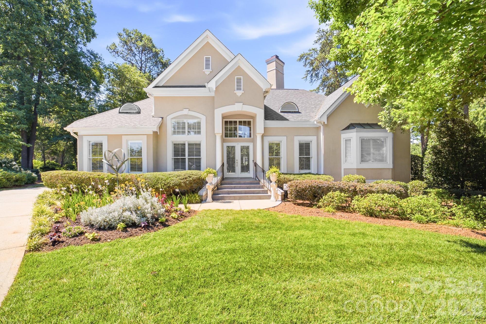 Nestled alongside the 13th hole of the prestigious Peninsula Club Golf Course, this elegant stucco home offers breathtaking golf course views and a thoughtfully designed floor plan perfect for both everyday living and entertaining. Step inside to a soaring two-story great room filled with natural light, where expansive windows showcase the picturesque fairway beyond. The open-concept layout seamlessly connects the living room, kitchen, and sunroom, creating an inviting space for gathering with family and friends. The private owner's wing features a spacious bedroom retreat, dual deep walk-in closets, and an en-suite bath complete with dual vanities, a soaking tub, and a walk-in shower. On the opposite side of the home, two generously sized guest bedrooms share a full bath, offering comfort and privacy for family or visitors. Upstairs, you'll find an additional bedroom, a full bath, and an open loft that serves beautifully as a second living area, media room, or home office. Outdoor living is equally impressive, with a back deck overlooking the golf course and leading to a beautifully landscaped garden area surrounded by lush green lawn. Combining elegant design, spacious living areas, and a premier golf course setting, this exceptional home offers the best of Peninsula Club living.