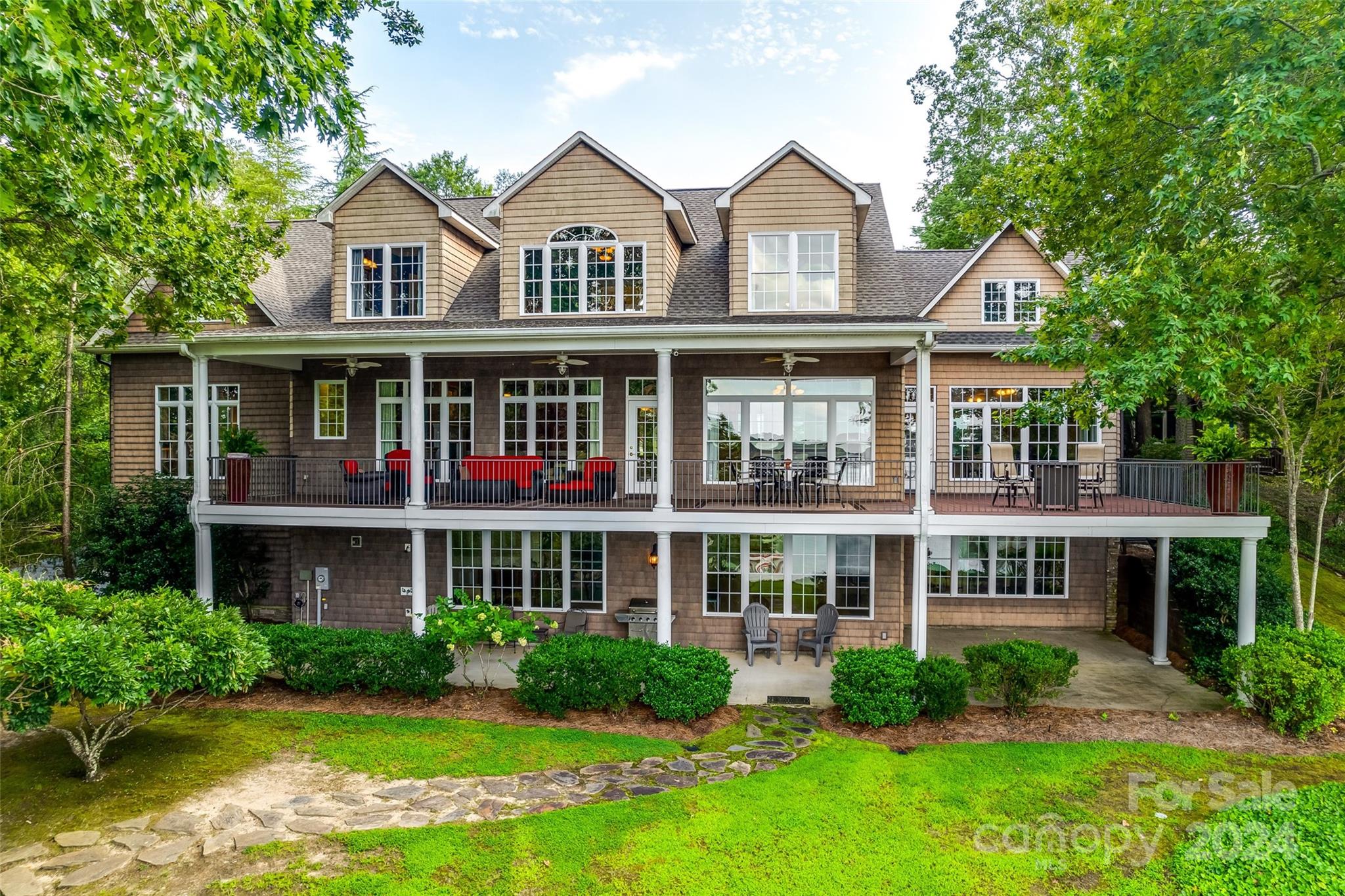 Stunning! Builders custom Lakefront retreat with expansive big water views from nearly every room. This elegant home features a spacious covered back porch (45’x12’) and open entertainment area (18’x22.5’) on the main level, plus a lower patio and its own private sandy beach for lakeside fun. Large covered floating boat dock with Two Jet Ski parking spots. Enjoy two luxurious primary suites with walk-in closets and lake views – one on the main level and one upstairs. Interior Highlights include Brazilian cherry floors, 10’ ceilings, three fireplaces, and a chef’s kitchen with a large island, extra beverage fridge, two ovens, and two sinks. The 2000 sq.ft. partially unfinished walk-out basement, oversized garage, boat lift, and lake irrigation system complete this perfect blend of luxury, comfort, and endless possibilities! Truly a must see to appreciate it. Low SC taxes, with easy access to I-77 and a short commute to Charlotte or Rock Hill.