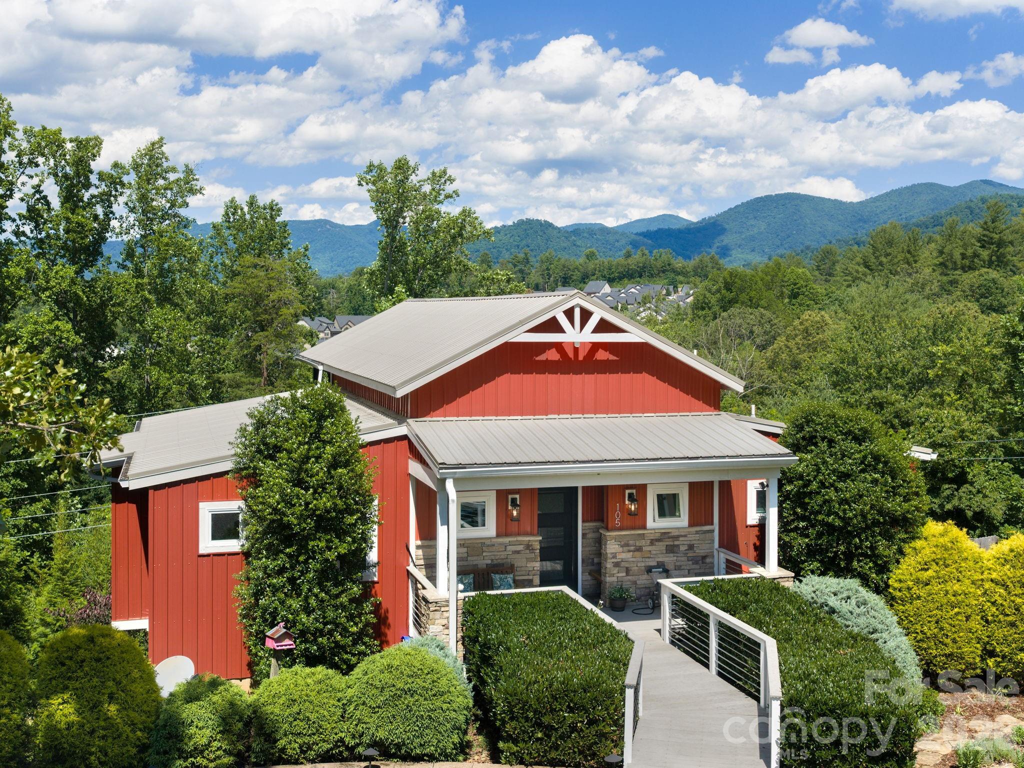 Discover 105 Upper Grove Lane, an Arts & Crafts custom-built masterpiece situated in the sought-after Reems Creek area of Weaverville. This property offers breathtaking, year-round mountain vistas just six minutes from the charm of Historic Downtown Weaverville and fifteen minutes from the heart of Asheville. The home’s open and airy floor plan transitions seamlessly, centered around a magnificent great room with soaring ceilings, a modern recessed gas fireplace, and expansive windows designed to frame the surrounding mountains. A chef’s dream, the kitchen features a large gas range, integrated wine cabinetry, and a substantial island perfect for hosting. The owner’s suite serves as a serene sanctuary, complete with direct porch access and a garden tub positioned to enjoy the mountain scenery. Visitors will appreciate the privacy of the lower level, which includes two spacious bedrooms, a full bath, a cozy den, and a private covered porch. Additional amenities include a pristine three-car garage, a level driveway for easy parking, a generator, and a vaulted main-level deck. Combining exquisite craftsmanship with a prime location, this residence is an ideal match for those seeking the best of Western North Carolina’s natural beauty and cultural vibrance.