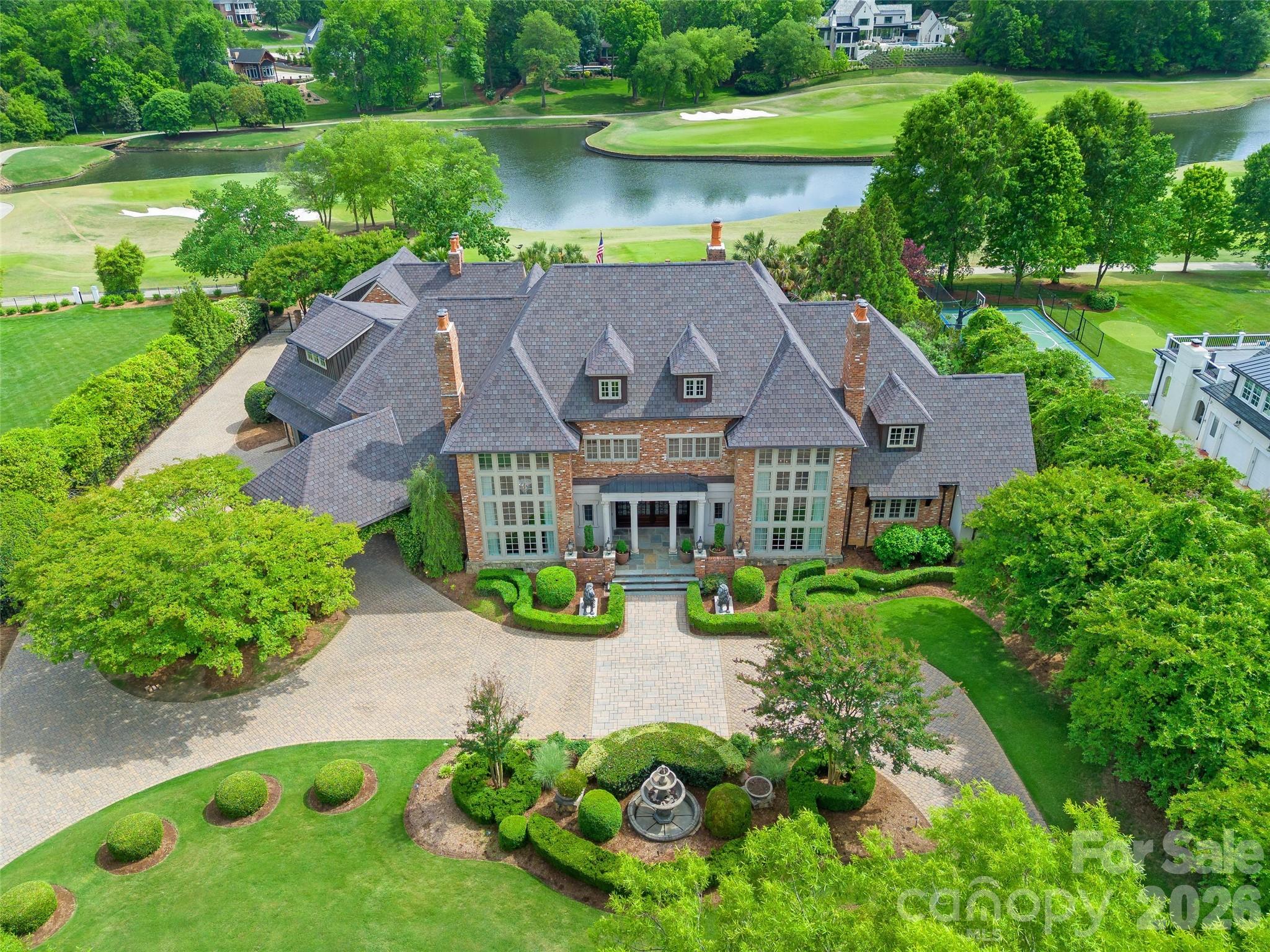 Experience CLT's FINEST in Carmel Estates! This stunning custom estate is located on the esteemed Carmel Country Club golf course (#16 with views of #14 and #15), on a picturesque 1.24 acres & encompasses ~9,800 square feet. The main home features 5 bedrooms, 5 full bathrooms, 2 half bathroom & over 8,800 square feet. The pool house/exercise room/guest cottage features 1 full bathroom, exercise room, outdoor fireplace, garages, storage, outdoor kitchen & 955 square feet. As you enter the gated estate, the inviting circular driveway with porte-cochère & fountain lead you to the grand entry with immediate views of the resort style backyard & golf course. The main level features floor to ceiling windows, elegant 2 story dining room with fireplace, 2 story living room with fireplace, study with wood paneling overlooking the backyard & golf course, chef's kitchen with Viking & SubZero appliances, oversized island & a breakfast room with a view overlooking the family room with fireplace, wine cellar, wet bar, walk-in pantries & large laundry room. The luxurious primary suite is located on the main floor & features a sitting room, his & her bathrooms & 2 walk-in closets. Two staircases & elevator to the upper level featuring 4 bedrooms, 3 full bathrooms, second floor laundry room & incredible bonus room spaces. This home is an entertainer's dream featuring incredible indoor/outdoor spaces for all 4 seasons, resort pool with spa, pool bathroom, outdoor fireplace, fire pits, oversized backyard & more. Located in the heart of South Charlotte within close proximity to the finest shopping, dining & lifestyle the Queen City has to offer!