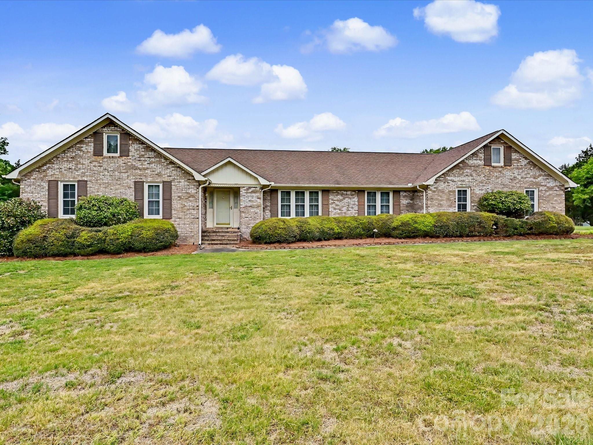 Tucked into the sought-after Carolando neighborhood in Concord, NC, this charming ranch-style home offers space, privacy, and timeless appeal on nearly a full acre of land. With 4 bedrooms and 2.5 baths, the layout is both functional and inviting, perfect for comfortable everyday living and easy entertaining. Inside, you’ll find a spacious living area centered around a fireplace that has never been used, offering a pristine focal point ready for cozy evenings or left as a decorative feature. The home’s single-level design provides convenience and flow, with generous room sizes and plenty of natural light throughout. Step outside on your private patio and enjoy the peace and openness of the expansive lot, with an additional vacant lot next door that will remain unoccupied—giving you an extra sense of privacy and room to breathe. Whether you envision a garden, outdoor entertaining space, or simply a quiet retreat, the possibilities are wide open. A 2-car garage adds practicality, while the home’s location near Charlotte Motor Speedway keeps you close to local attractions, dining, and commuter routes without sacrificing the calm of a well-established neighborhood. This property blends classic ranch-style comfort with rare outdoor space in a desirable area—an opportunity that doesn’t come around often.