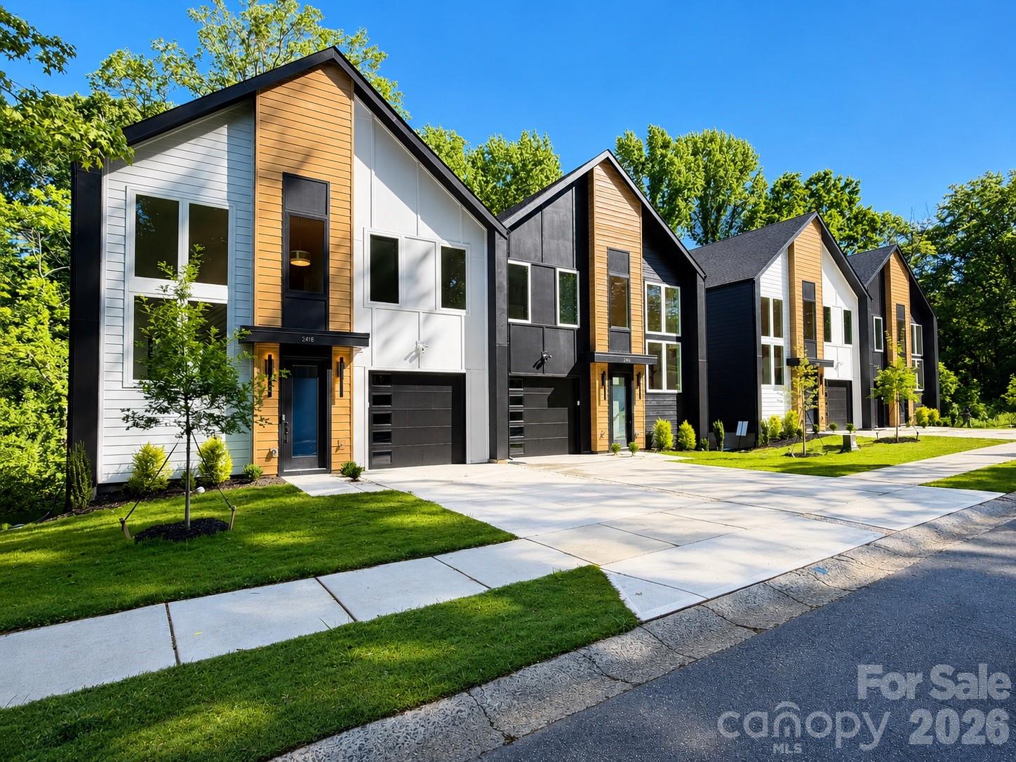 Welcome to the Crestview Duets — a rare opportunity to own a modern, design-forward home just minutes from Uptown Charlotte. This move-in ready 3-bedroom, 2.5-bath residence blends bold contemporary exterior architecture with upscale interior finishes across an open 2,300-sq-ft layout. The home features a dramatic two-story stairway framed by oversized windows that flood the interior with natural light. The gourmet kitchen offers quartz countertops, soft-close cabinetry, upgraded gold and matte-black hardware, and an oversized island flowing seamlessly into expansive living spaces. A private office with glass doors, shiplap accents, RevWood flooring, 9’ ceilings with tray detail in the primary suite, walk-in closet, and spa-inspired baths elevate daily living — including a huge owner’s suite shower with rainfall head. Outside, enjoy an exceptionally deep, private backyard backed by a protected Tree Save area, plus a full-width composite deck with privacy wall and covered patio — a rare level of outdoor space and seclusion. Located on a quiet residential street with space to breathe, yet steps from the Gold Line, walkable to the park, 5 minutes to Uptown, and 11 minutes to CLT Airport. No HOA. EV-ready garage.
