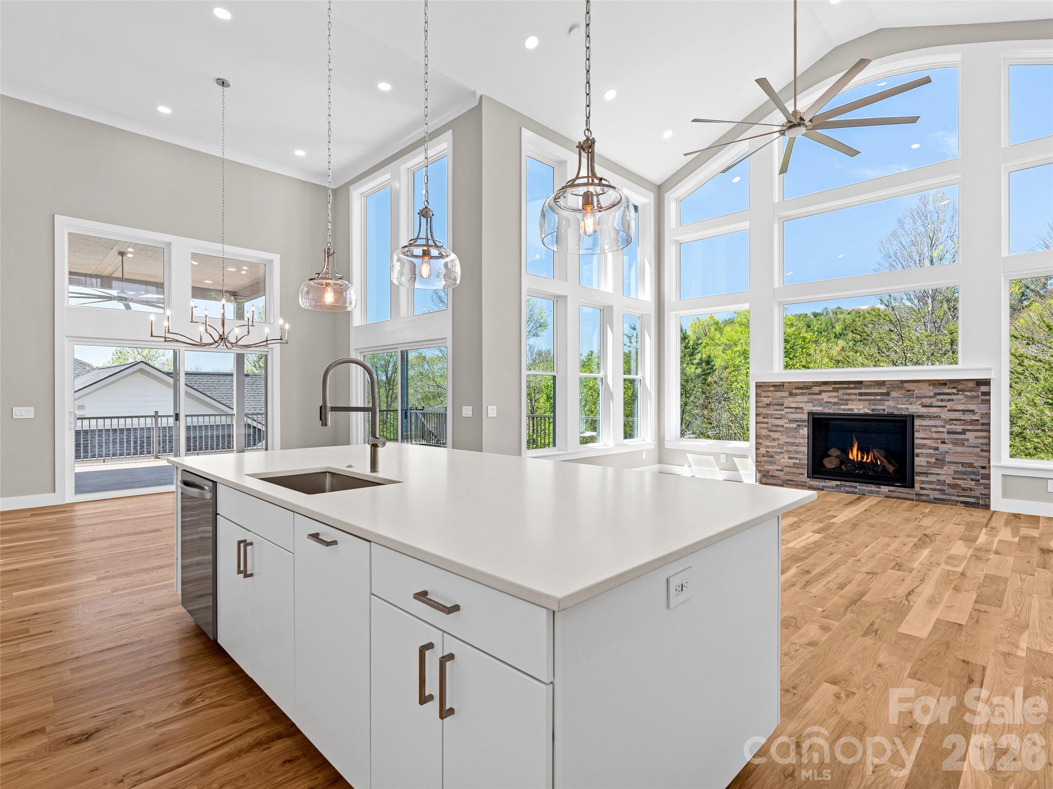 Newly completed, this Weaverville estate is defined by its 18-foot window-wall, centered upon a grand fireplace, and overlooking acres of forested creekside greenway. This custom design showcases two vaulted primary suites, a mountain-view office or guest ensuite entered through French doors, expansive decks—both covered and open, and a chef’s kitchen grounded by its luxury island. A spacious laundry room connects to the lofted, EV-ready garage, fitted with an RV bay.

A dramatic open-air stair leads down to two distinct terrace-level wings. One wing offers a private guest retreat with bedroom, bath, living area, wet bar, and walk-out 500-square-foot patio. The second is a fully independent two-bed, one-bath suite with private exterior access, a dedicated driveway, kitchen, laundry, pantry, and living area.

Additional features include a 24 kW generator, 400-amp service panel, high-efficiency Trane heat pump with gas furnace on the main level, and dual-zone heat pump serving the terrace level. Built for HERO and Energy Star certifications.

Located in Greenwood Park alongside neighboring Reems Creek Village, this established community is known for custom homes, quiet streets, and sweeping mountain views—south and east to the Blue Ridge, west to Pisgah and the Smokies, and north to Hamburg Mountain. Convenient to Reems Creek Golf Club, downtown Weaverville, Asheville, the Blue Ridge Parkway, and the area’s upcoming hospital.

Open House Mon - Sun 1PM to 3PM