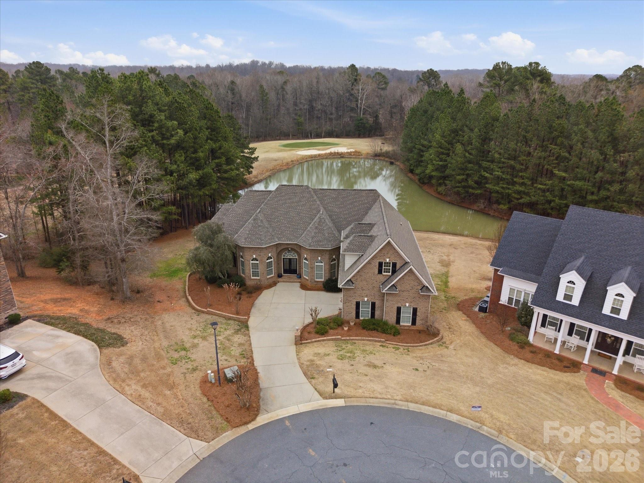 Enjoy sweeping views of the 11th hole at Waterford Golf Club and a tranquil pond from this custom-built French Country estate by Haines Maxwell, ideally tucked away on a quiet cul-de-sac in the prestigious Waterford Glen community. Fresh paint throughout the entire main floor enhances the light-filled interior. Coffered ceilings accent the great room, and the gourmet kitchen showcases dual sink prep areas, custom cabinetry, and high-end stainless appliances including a gas range. This home features a desirable split-bedroom layout, with each bedroom offering a private bath and two walk-in closets. The spacious primary suite offers private deck access, dual vanities, walk-in shower, and two walk-in closets. The expansive back porch captures sweeping golf course and water views perfect for relaxing or entertaining, while the yard’s in-ground irrigation system keeps the landscape lush and beautifully maintained year-round. The expansive back porch captures sweeping golf course and water views—perfect for relaxing or entertaining, while the yard’s in-ground irrigation system keeps the landscape lush and beautifully maintained year-round.. The lower level includes two bedroom suites, a workshop, and unfinished space plumbed for a future bar and wine cellar. An unfinished bonus area over the garage is also plumbed for a full bath, ideal for a fifth bedroom or flex space. Recent updates include a new roof (2023), new plumbing (2023), rebuilt deck (2022), and a first-floor HVAC system less than two years old, plus a tankless water heater. Seller will share original architectural plans if desired. Patio furniture can remain at buyer’s request.