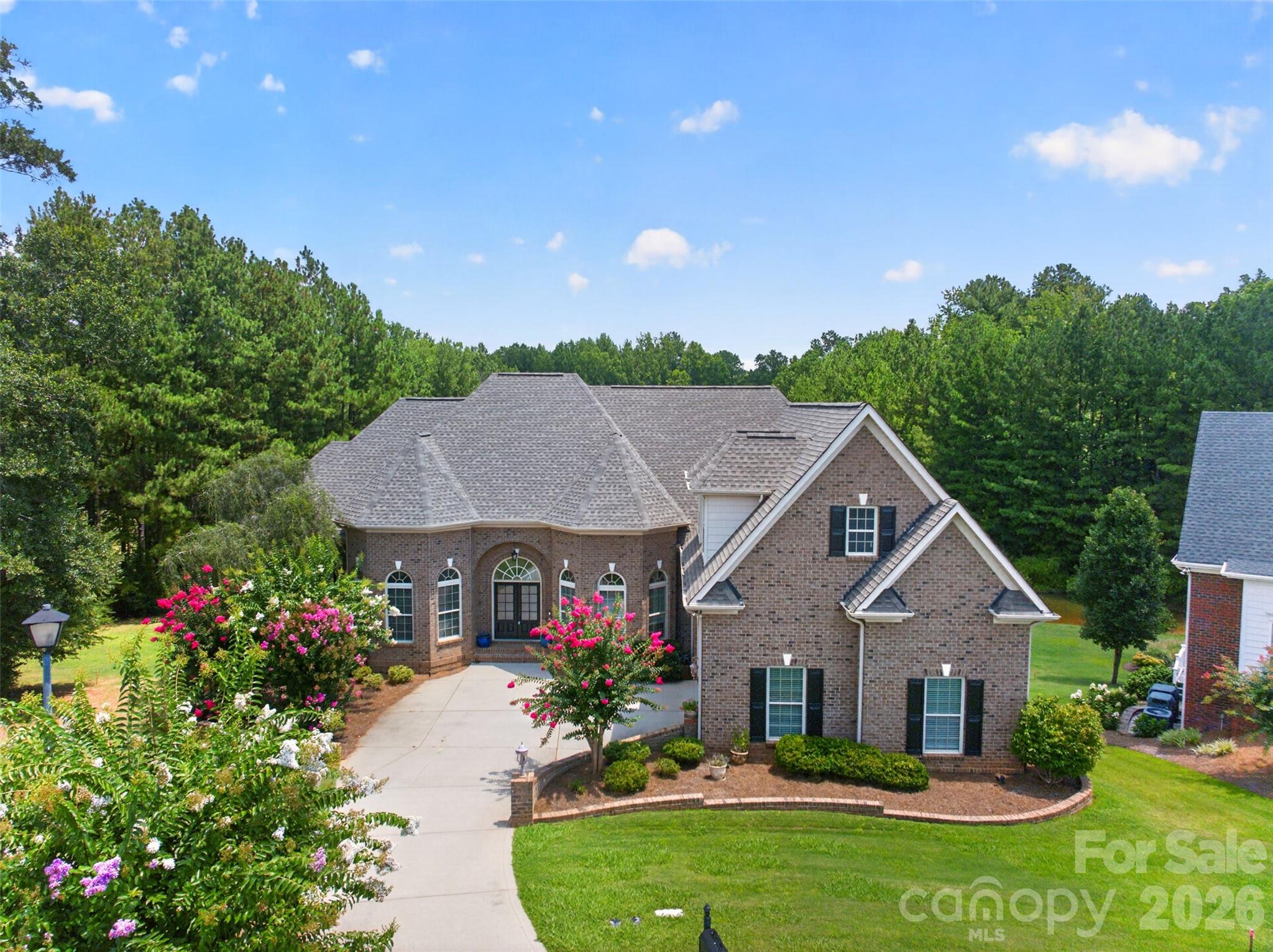 Enjoy sweeping views of the 11th hole at Waterford Golf Club and a tranquil pond from this custom-built French Country estate by Haines Maxwell, ideally tucked away on a quiet cul-de-sac in the prestigious Waterford Glen community. Fresh paint throughout the entire main floor enhances the light-filled interior. Coffered ceilings accent the great room, and the gourmet kitchen showcases dual sink prep areas, custom cabinetry, and high-end stainless appliances including a gas range. This home features a desirable split-bedroom layout, with each bedroom offering a private bath and two walk-in closets. The spacious primary suite offers private deck access, dual vanities, walk-in shower, and two walk-in closets. The expansive back porch captures sweeping golf course and water views perfect for relaxing or entertaining, while the yard’s in-ground irrigation system keeps the landscape lush and beautifully maintained year-round. The expansive back porch captures sweeping golf course and water views—perfect for relaxing or entertaining, while the yard’s in-ground irrigation system keeps the landscape lush and beautifully maintained year-round.. The lower level includes two bedroom suites, a workshop, and unfinished space plumbed for a future bar and wine cellar. An unfinished bonus area over the garage is also plumbed for a full bath, ideal for a fifth bedroom or flex space. Recent updates include a new roof (2023), new plumbing (2023), rebuilt deck (2022), and a first-floor HVAC system less than two years old, plus a tankless water heater. Seller will share original architectural plans if desired. Patio furniture can remain at buyer’s request.