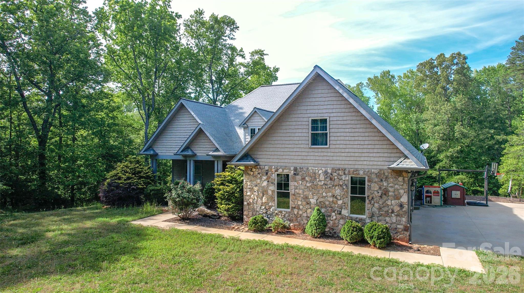 Set on approximately 15± acres just outside Boiling Springs, NC, 2015 this custom-built home offers a rare blend of quality craftsmanship, privacy, and exceptional land features. The 4-bedroom, 2-bath home welcomes you with warm hardwood floors, granite countertops, beautifully crafted custom cabinetry and a private primary bedroom suite.  
Inside, you’ll find vaulted ceilings, a striking rock fireplace, and large windows that fill the home with natural light while showcasing the surrounding landscape. The spacious layout flows seamlessly to a large back deck with low-maintenance composite decking, perfectly positioned to overlook a private, expansive backyard that is ideal for relaxing or entertaining.
The land itself is truly special, featuring mature timber and a rich history of deer and turkey hunting, making it a haven for outdoor enthusiasts. Flowing through the property is the impressive Grog Creek, with a strong, year-round flow and an old grist mill dam that often creates a stunning waterfall feature. 
Additional highlights include a two-car garage with a heated and cooled bonus room above that would be perfect for a home office, guest space, or recreation area. The full, walk-out basement offers incredible expansion potential, already plumbed for an additional bathroom and framed with interior studded walls for future bedrooms and a family room.
Whether you’re looking for a custom built home on acreage, a unique recreational or hunting property, or a place to grow and customize, this unique property delivers the best of country living with convenient access to nearby amenities including Gardner Webb University and The Broad River Greenway.
