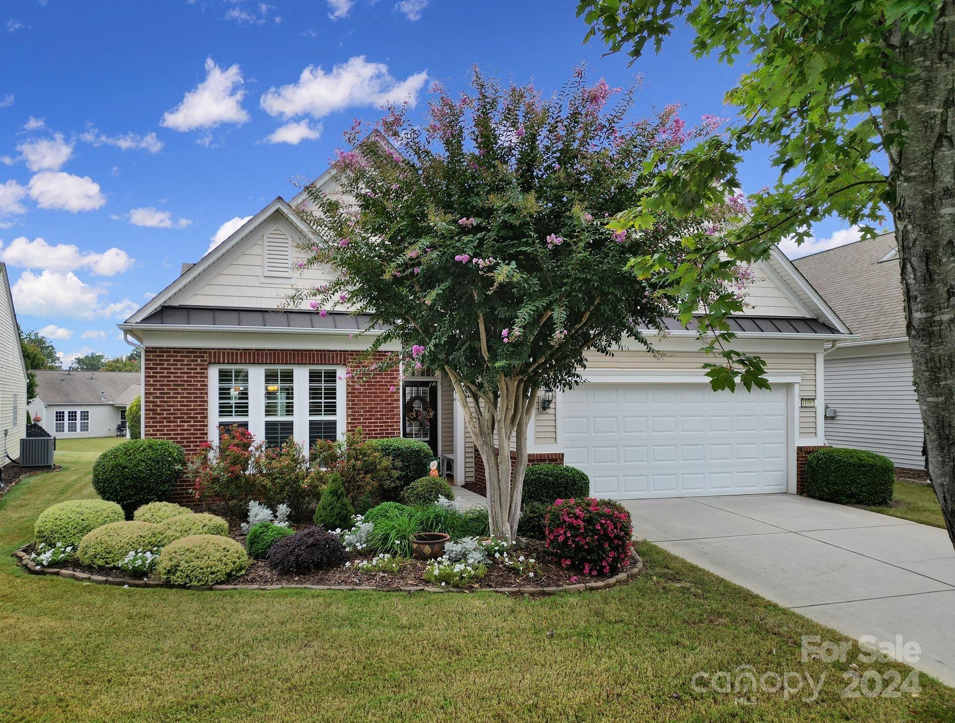 Beautiful Willow Bend home w/ tasteful upgrades & a lovely back patio! Instantly notice the plantation shutters, hardwood floors, trim work, and ample amount of natural light! Cook meals in the eat-in kitchen with SS appliances, granite counters, a large island w/ bar seating, & a built-in desk area. The open flow of the formal dining area, great room, and sunroom is great for entertaining! You'll enjoy the coziness of the gas fireplace in the winter months. Primary suite at the rear of the home boasts a tray ceiling and an updated bathroom w/ dual vessel sinks, a soaking tub, & a walk-in closet. A den with French doors will make the perfect home office or hobby room. Relax on the extended paver patio underneath the pergola while enjoying the manicured backyard with established landscaping and a paver sitting wall! 2-car finished garage w/ epoxy floors & extra lighting! Don't wait to come join the active-adult lifestyle in Sun City Carolina Lakes!