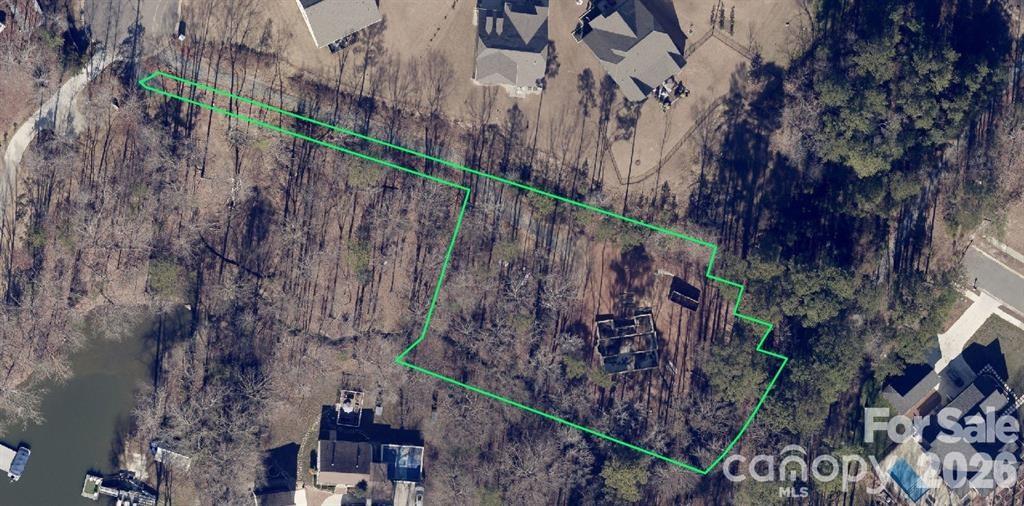 A .92 acre partial winter lake view lot on a gorgeous mature wooded parcel. Private, secluded living in the midst of the Palisades community. No HOA! The site consists of a 40 x 42 foot poured concrete basement walkout foundation. Concrete slab floor with sump pump drainage in place. 10 foot walls with “French drain” 10 inches thick. LVL beams and posts in place for construction of the home of your design. Water & sewer lines have been installed. All inspections, RDP and UDO reports completed and available. Minutes to the beautiful shores of Lake Wylie, great reasturants, and shopping! Please do not walk the property without booking a showing appointment! Many trip and fall hazards.