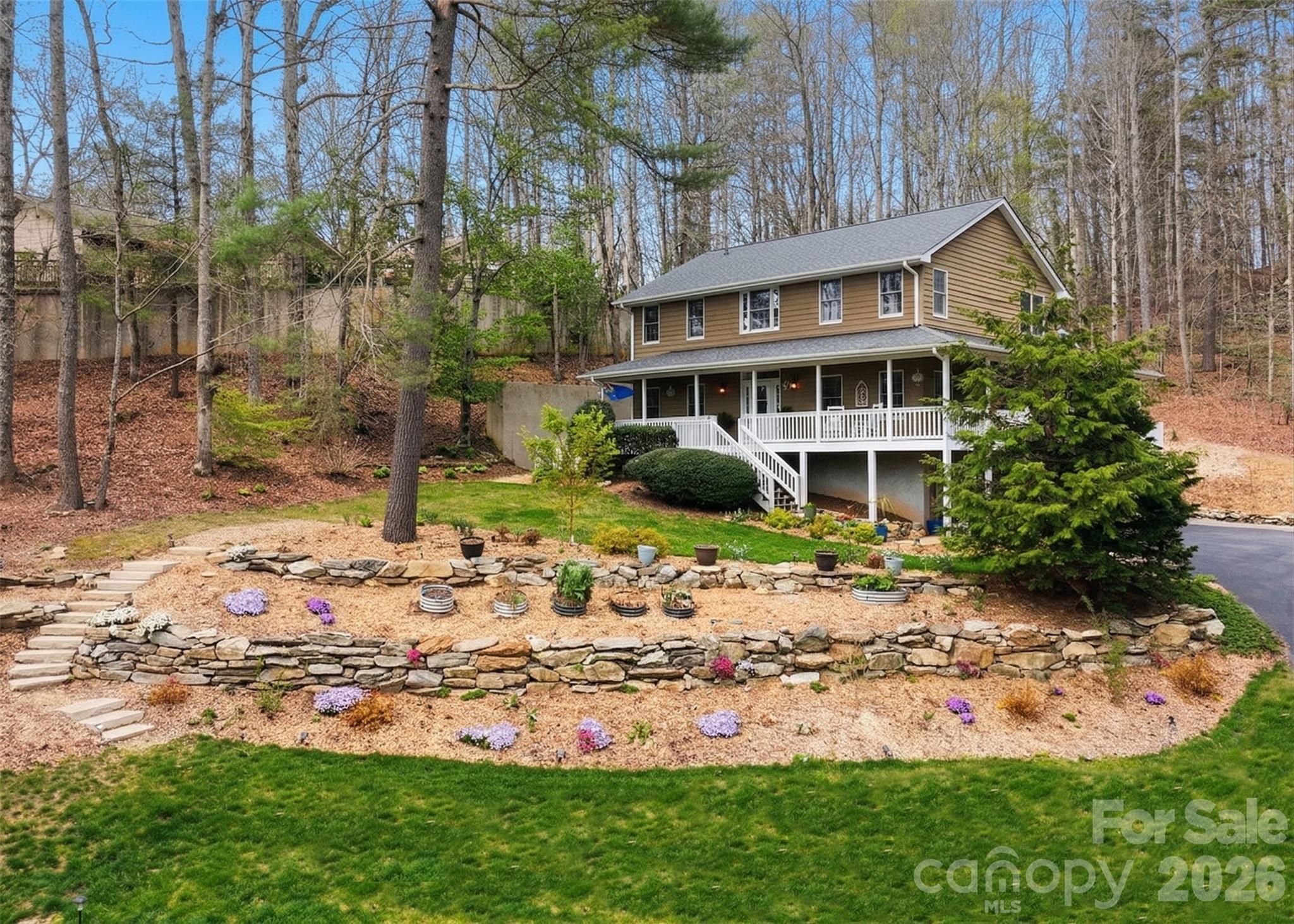 If you're searching for a move-in ready home here in the mountains of North Carolina, then 94 Squirrel Trail is the home you've been dreaming of!

Offering tasteful updates throughout, 94 Squirrel Trail includes a fully renovated kitchen, updated bathrooms, elegant hardwood floors across the main and upper levels, a soaring great room with a gas log fireplace, and a stunning down-home wrap-around covered porch that's the perfect place for relaxation on those quiet summer evenings.

This 3-bedroom, 3.5-bathroom home offers over 3,200 square feet of finished living space in the established Sweetwater Hills neighborhood, perfectly perched in the Mills River area and conveniently located between Hendersonville and Asheville. Terrific school districts, convenient access to shopping, restaurants, first-class healthcare services, easy airport access, and more; this is a location that's built around making your life easier!

The main level offers convenient spaces for everyday living. You'll love the freshly renovated kitchen with a dine-in breakfast area for morning coffee and conversation, a separate dining room, a dedicated laundry room tucked around the corner from the kitchen, and a large, private primary suite featuring his and hers closets, a double vanity and makeup table, and a separate tub and shower room.

Upstairs, the second floor provides flexible space for a variety of needs, including two bedrooms, a full bathroom, and an extra bonus room that's perfect for a dedicated home office.

Down below, you'll love all the additional space that makes this a step above what you've been looking for! Features include a two-car garage, an additional full bath, a bonus room with a closet that opens to a private courtyard, and a bonus living room with a gas fireplace and wet bar. Let your imagination fill these spaces... a craft room, multi-generational living/mother-in-law suite, a place for the unruly teens, additional work-from-home space, or a game day TV room... it's yours to create!

A rare offering with tremendous value, don't let this one get away!