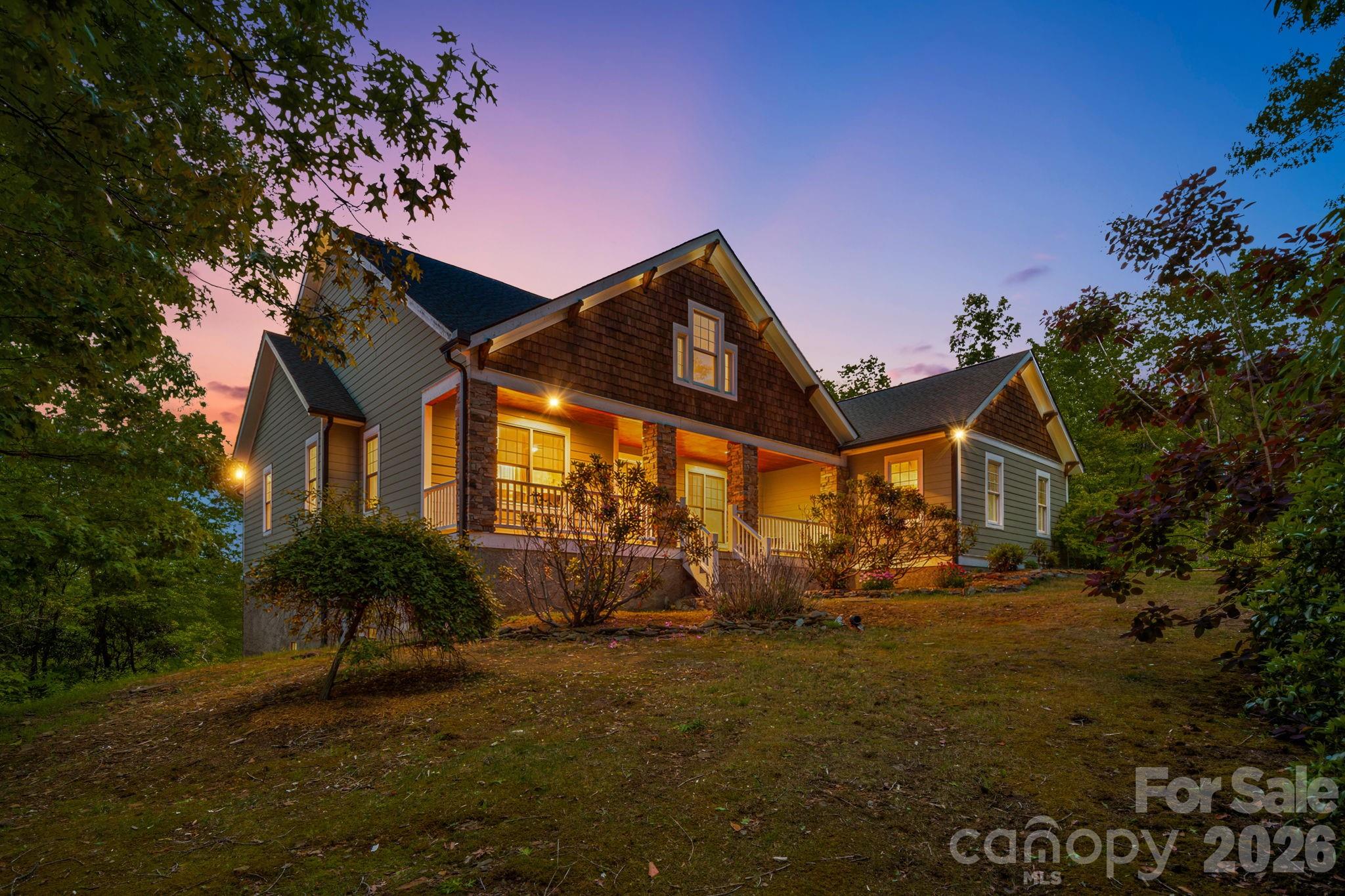 Beautiful mountain views surround this privately situated home in the High Rock Acres neighborhood. This secluded mountain retreat offers the perfect blend of comfort, nature, and convenience, just 12 minutes from downtown Black Mountain. Lovingly maintained by its original owner, the home showcases quality craftsmanship and peaceful mountain living on two private acres with stunning year-round views.
The thoughtfully designed home offers easy one-level living with 3 bedrooms and 2.5 bathrooms, featuring an open floor plan with beautiful vaulted ceilings, abundant natural light, and seamless indoor-outdoor flow. Hardwood flooring runs throughout the home, while expansive windows showcase the surrounding mountain scenery from multiple vantage points. The gourmet kitchen is equipped with high-end appliances including Miele and Wolf, creating an ideal space for cooking, gathering, and entertaining. The living area is centered around a cozy wood-burning fireplace, making the space feel both inviting and functional.
The spacious primary suite offers a peaceful retreat with mountain views, a spa-like bathroom, and two walk-in closets. Expansive decks extend the living space outdoors and provide the perfect setting for entertaining, outdoor dining, or simply relaxing while taking in the long-range views and incredible stargazing.
The flat front yard is a rare and usable mountain feature, offering space for gardening, play, or enjoying the peaceful setting with easy upkeep. A bedroom and full bathroom above the detached two-car garage provide excellent flexibility for guests, a private office, or additional living space. The garage also offers additional storage for outdoor gear, tools, or workshop space.
Private yet convenient, this special property offers the serenity of mountain living with easy access to downtown Black Mountain, local dining, shopping, and outdoor recreation including Lake Tomahawk.