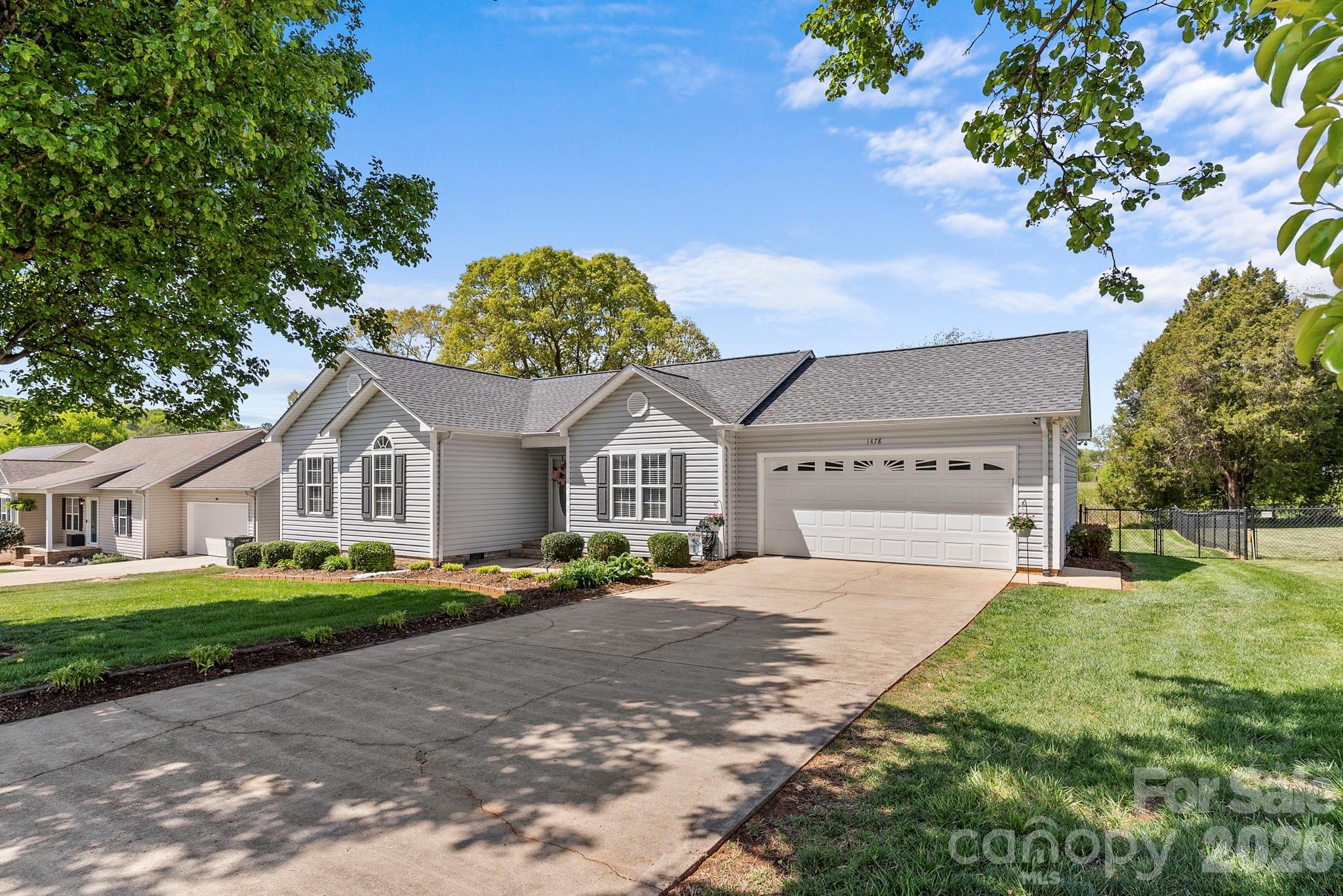 Welcome to this well-maintained home nestled in the quiet, welcoming neighborhood of Farmington Hills, offering the ease of one-level living on a great level lot with attractive landscaping and a fenced backyard—perfect for outdoor enjoyment, pets, or gardening. Inside, you’ll find a spacious living room featuring beautiful hardwood floors (which are throughout the home except for tile floors in baths), gas log fireplace, and built-in shelving, creating a warm and inviting atmosphere. The kitchen is nicely updated with newer stainless steel appliances, solid surface countertops, and quality wooden cabinetry, along with a convenient dining area just steps away. The primary bedroom includes a private ensuite bath and a walk-in closet, while two additional bedrooms and a full hall bath provide comfortable space for family or guests. Step outside to the back deck—an ideal spot for relaxing or entertaining—and enjoy the convenience of an attached two-car garage. Roof replaced in 2022 and HVAC replaced in 2024.  This location allows for easy access to several nearby cities, approximately 20 minutes to Hickory, 30 minutes to Statesville, and just 55 minutes to Charlotte. This Home combines comfort, convenience, and charm- ready for it's next Owner to enjoy! Broker interest.