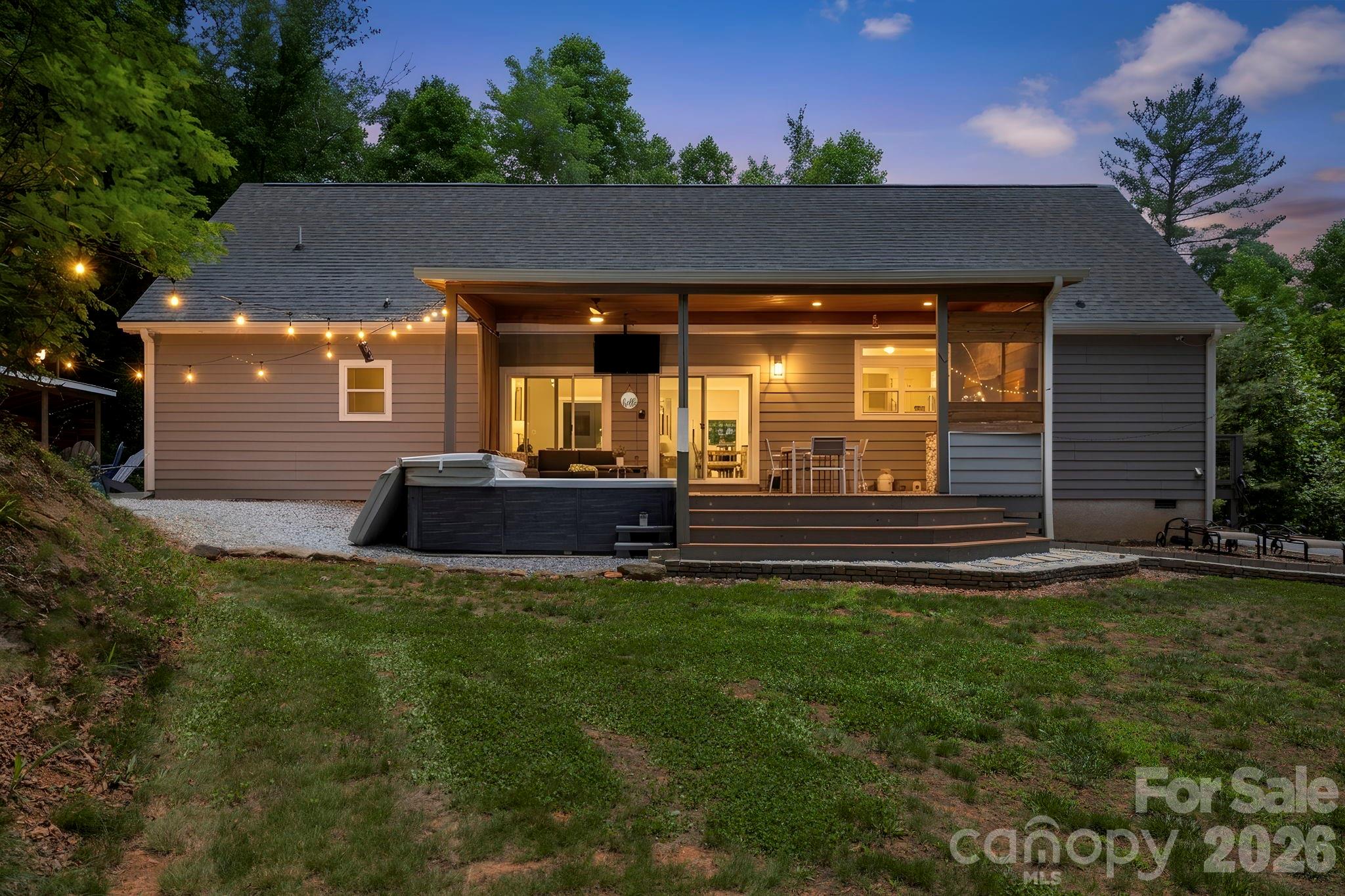 Nestled in the picturesque Village on Charming Lane, this stunning 2021-built mountain retreat offers the perfect blend of luxury, privacy, and modern mountain living on 2.6 wooded acres just outside Hendersonville. With over 3,100 sq ft, the home features 4 bedrooms, 3 full bathrooms, two separate living areas, a flex room, and an upstairs game room with pool and ping-pong tables providing plenty of space to relax, entertain, and gather. Designed for seamless indoor/outdoor living, two sets of sliding glass doors open to an expansive covered Trex deck complete with an outdoor kitchen featuring a built-in Blackstone grill and Kamado Joe smoker, outdoor dining area, TV lounge, XL hot tub, and fire pit. A short walk on the property leads to a private overlook with breathtaking long-range mountain and valley views. Conveniently located just 15 minutes from downtown Hendersonville, 20 minutes to Asheville Regional Airport, and 30 minutes to downtown Asheville, 311 Charming Lane offers the ideal combination of peaceful mountain living and easy access to the best of Western North Carolina.