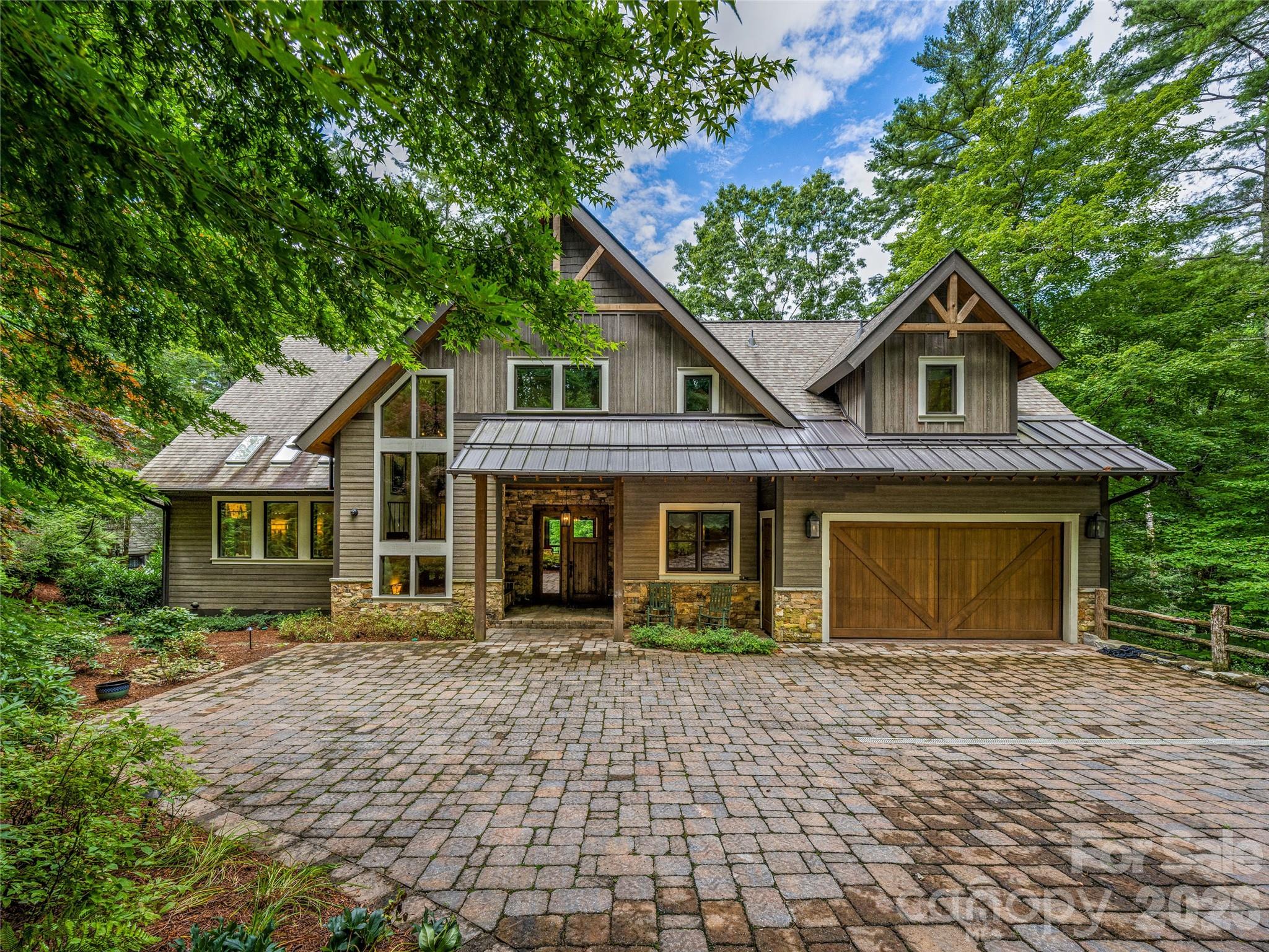 Experience lakeside luxury in this magnificently updated 5-bedroom, 3-story home on stunning Lake Toxaway. This hidden gem, nestled peacefully off of Skiers Cove, is a light-filled retreat boasting soaring ceilings, vibrant, artfully designed interiors, and expansive living spaces perfect for entertaining or a summer with the entire family. A state-of-the-art media room offers an immersive experience, while the colorful, thoughtfully curated rooms provide warmth and personality throughout. Nano doors in the living room open fully to connect indoor and outdoor living. Enjoy an outdoor kitchen for effortless entertaining, a sunken hot tub just off the master bedroom’s private porch, and an old world-style wine cellar for your finest vintages. Step outside to your private boathouse and dock—ideal for endless days on the water. This is mountain-lake living at its most extraordinary.