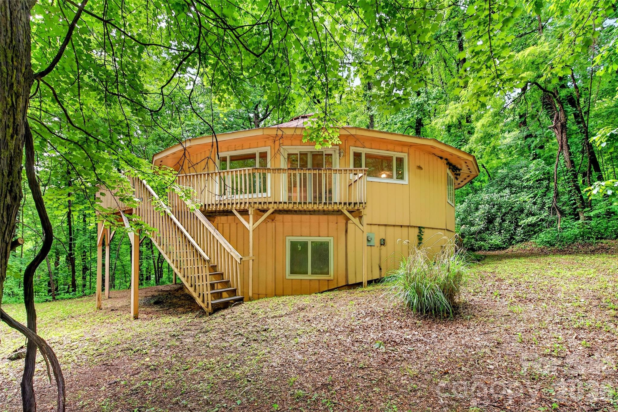 Escape to the mountains and create your dream retreat in this unique round Deltec home. Nestled on a level and private 4.68-acre tract, this property offers the opportunity to own your own slice of Western North Carolina paradise.

Located inside the gated community of Gateway Mountain in up-and-coming Old Fort, this home places you in the heart of one of the region’s fastest-growing outdoor recreation destinations. Enjoy easy access to hiking and biking trails, waterfalls, and endless mountain adventures while still being just a short drive to Lake Lure, Chimney Rock, Black Mountain, Asheville, and more. Gateway Mountain offers a true mountain atmosphere with peaceful surroundings, paved roads, and convenient access to nearby attractions, making it the perfect basecamp for full-time living, vacationing, or investment potential.

Inside, the charming woodstove creates a warm and inviting living space perfect for cozy mountain evenings. This home is ready for your finishing touches, giving you the opportunity to bring your own vision to life and make it truly your own. The main level features a spacious primary bedroom with an en suite bath, while the gorgeous wood floors are already in place and waiting to be finished to your taste. Take in the beauty of the outdoors through the panoramic windows that fill the home with natural light and mountain atmosphere.

The basement area offers excellent potential for additional bedrooms, recreation space, storage, or workshop area, etc. Whether you’re searching for a weekend getaway, mountain basecamp, short-term rental opportunity, or future forever home, the possibilities here are endless.

Mountain living at its best awaits. Property is being sold AS-IS / WHERE-IS. Deck needs replaced. Please DO NOT ENTER DECK AREAS.