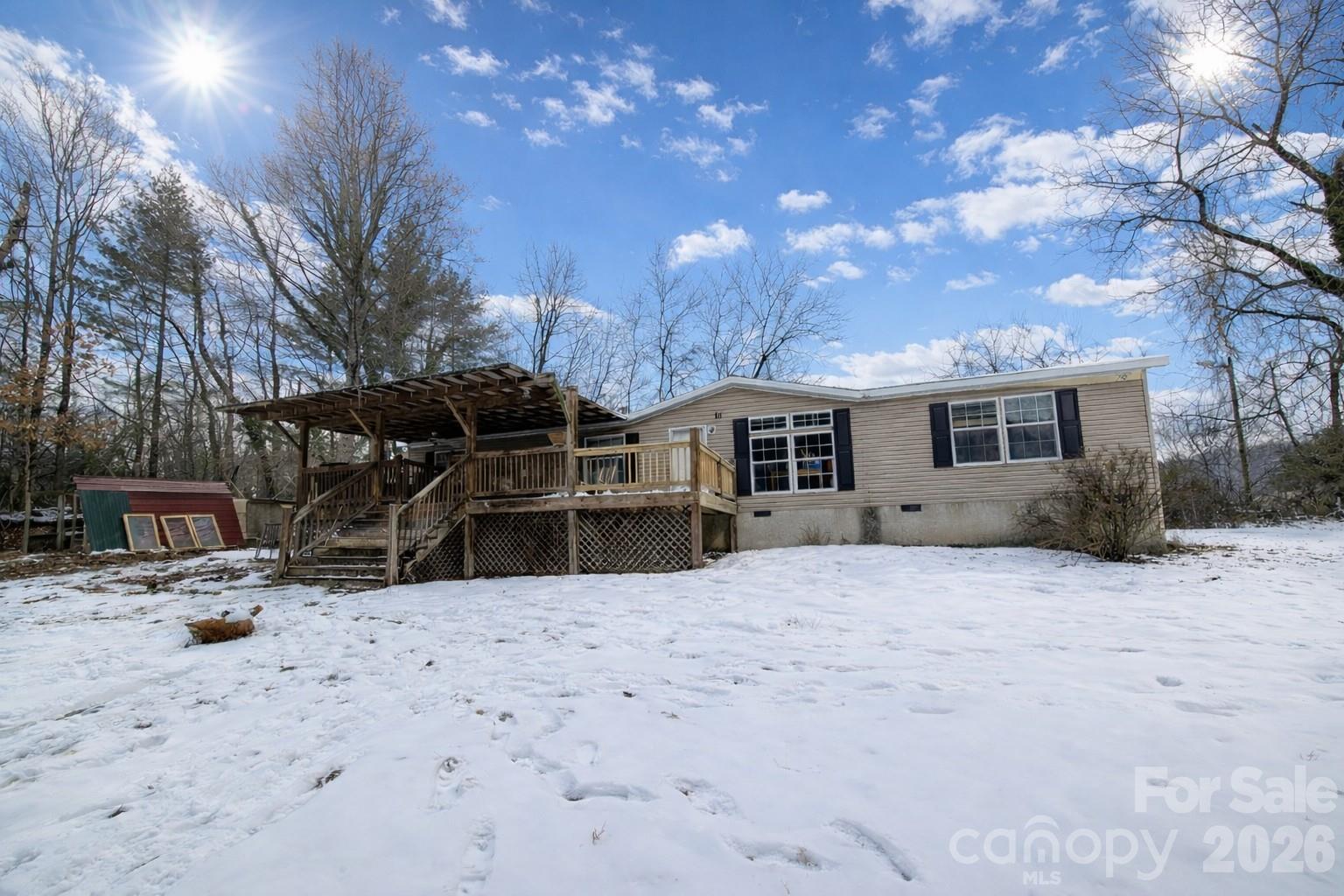 Just a short walk to the heart of downtown Black Mountain, this spacious 2005 double-wide offers comfort, character, and convenience on nearly half an acre. Featuring over 1,500 square feet, the home includes three bedrooms and two baths, a welcoming family room with a wood-burning fireplace, a dedicated dining area, and a cozy living room just off the primary bedroom—perfect for a private retreat, office, or sitting area.
Recent upgrades include a new HVAC system, new hot water heater, and new flooring throughout, providing peace of mind and modern comfort. Step outside to enjoy the large covered front porch, ideal for relaxing and taking in the mountain air. The gently sloping property includes multiple outbuildings and unique multi-level stonework sourced from the historic Black Mountain Inn, adding timeless character and a story you won’t find anywhere else.
An excellent opportunity for full-time living, a mountain getaway, or an investment—this home combines space, history, and one of Black Mountain’s most walkable locations.